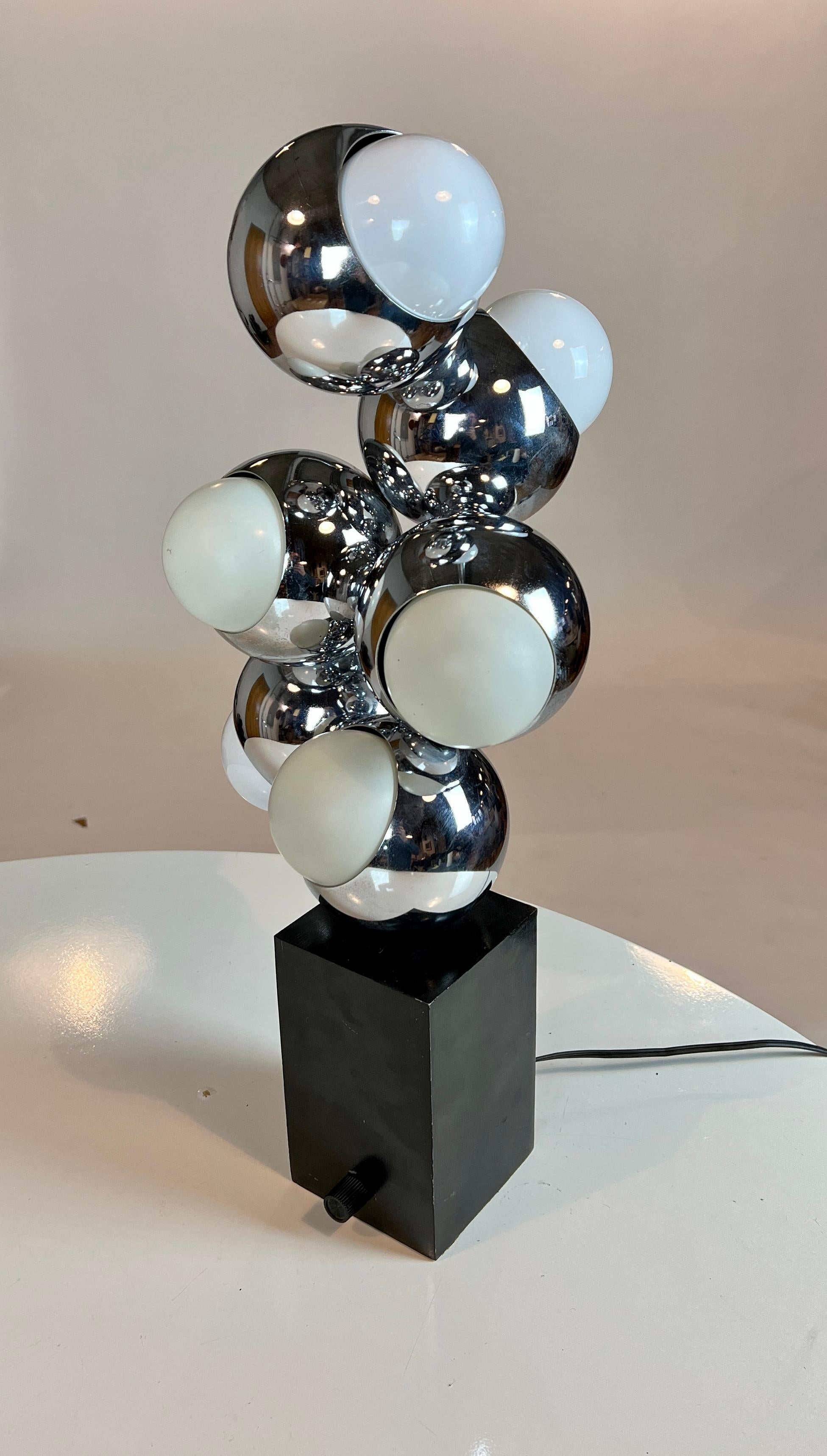 Space age vintage molecule or sputnik design table lamp in polished chrome on a black plinth with a dimmer knob. All sockets tested and in good working condition.
  