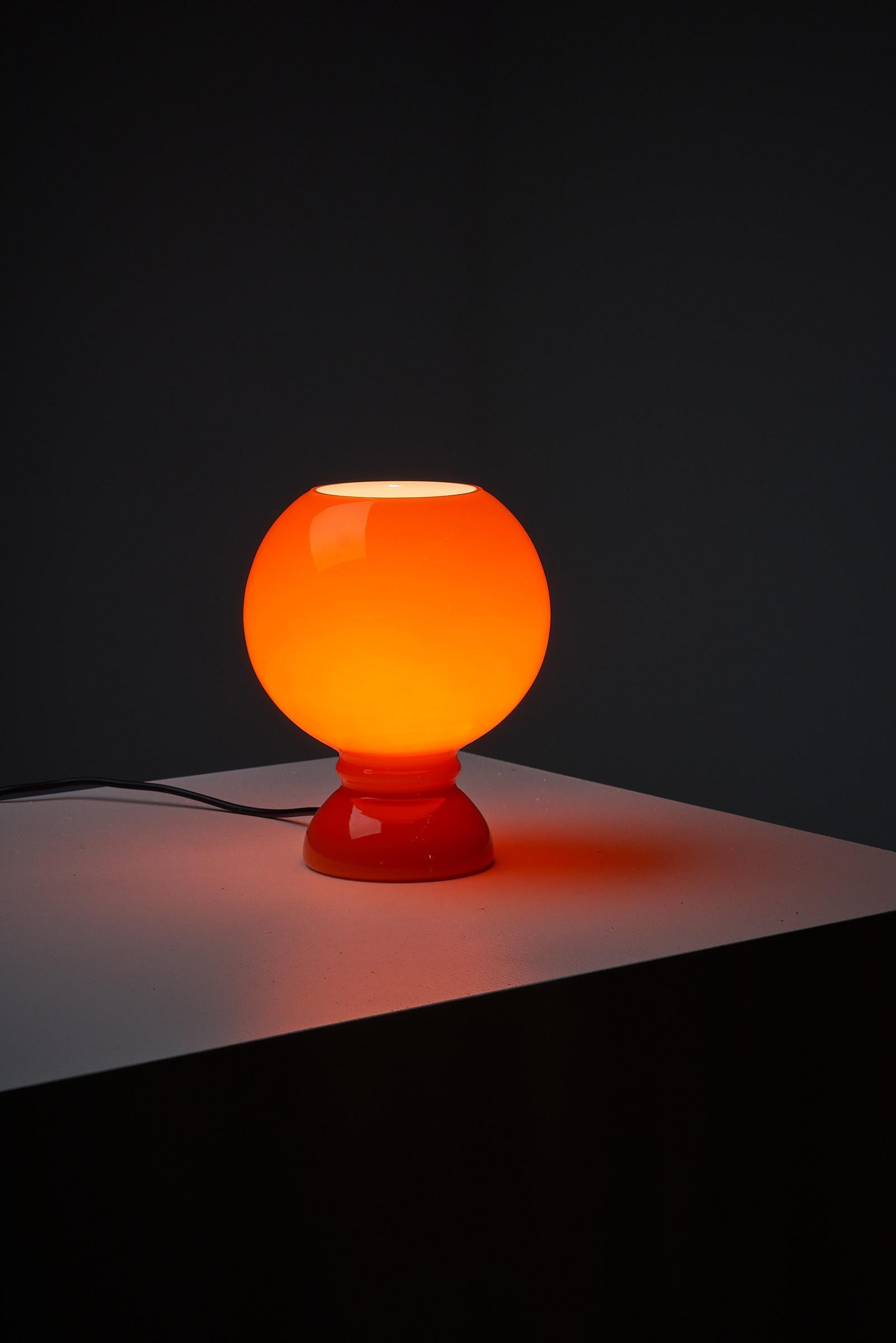 Très belle lampe de table de l'ère spatiale. Entièrement en verre. Le verre a une couleur orange et est blanc à l'intérieur. Il y a de très belles formes organiques dans l'ensemble de la pièce.