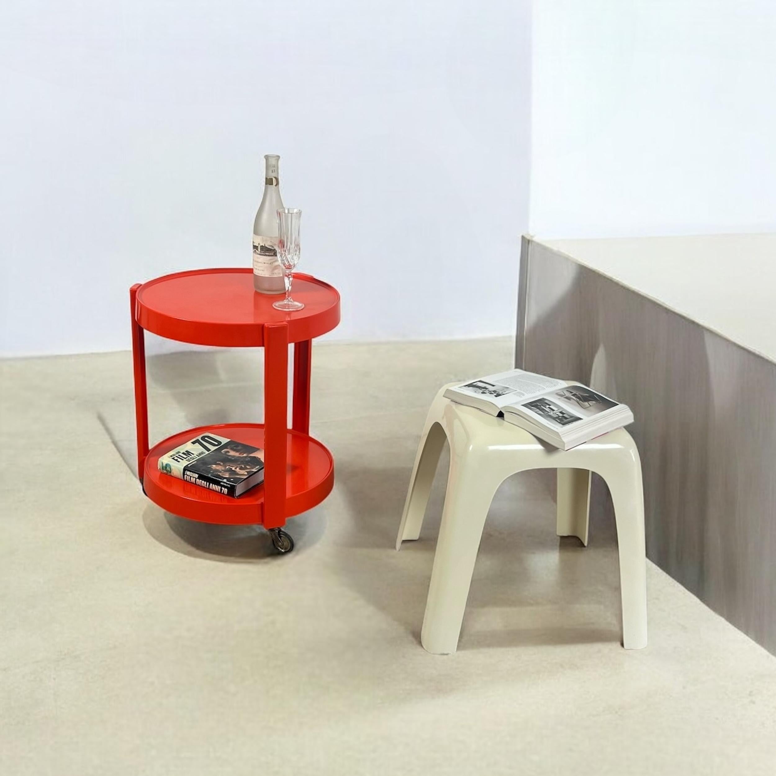 A charming blend of form and function, this vintage bar cart from the 1970s stands as a testament to Italy’s renowned design legacy. Fashioned from a striking orange plastic, this circular trolley exudes effortless elegance, with two spacious