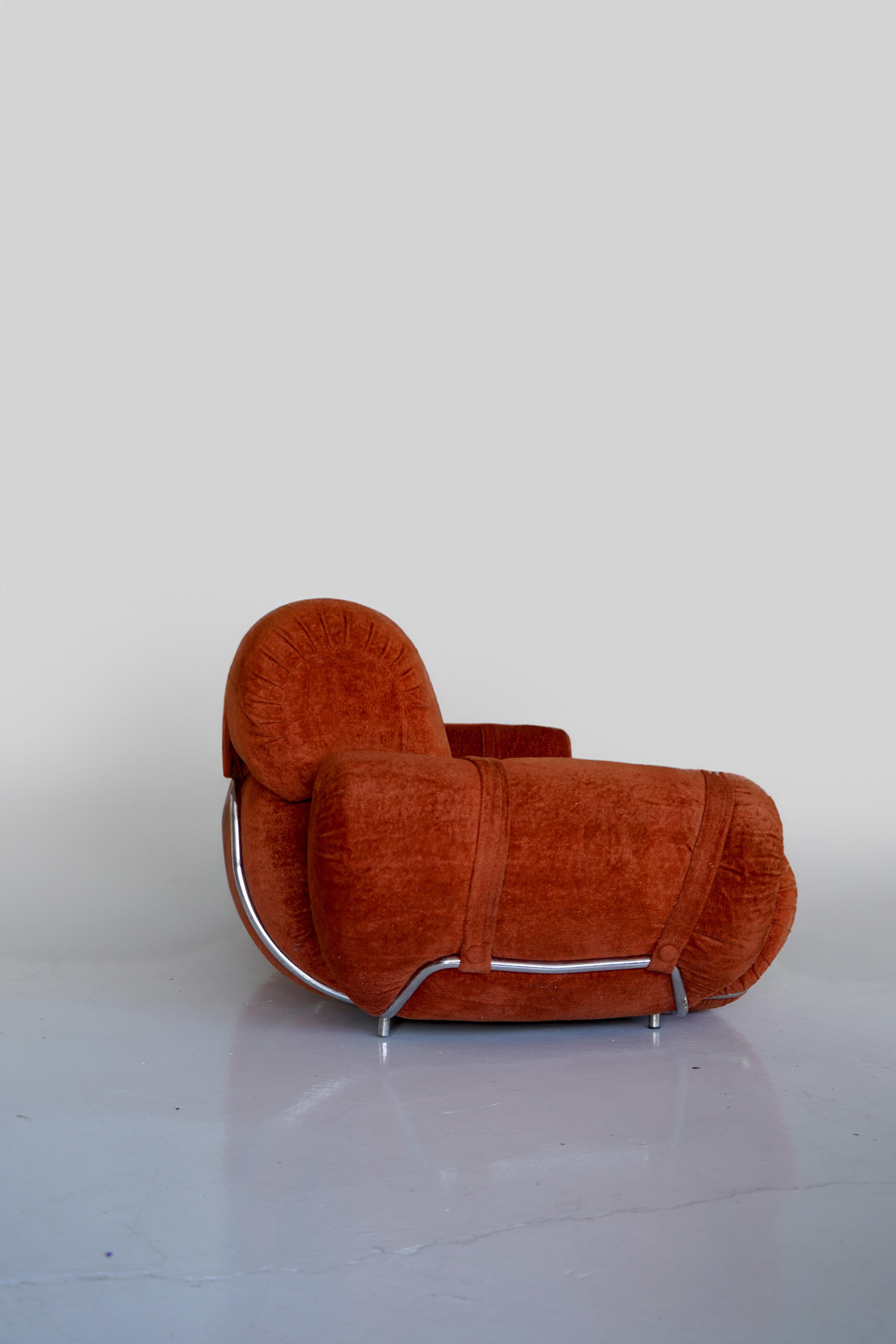 Chubby Italian space age sofa with chrome frame in a vibrant orange velvet. Straps on the arms and backs add a layer of elegance to the exuberant design. Remains in good vintage condition with minor wear.