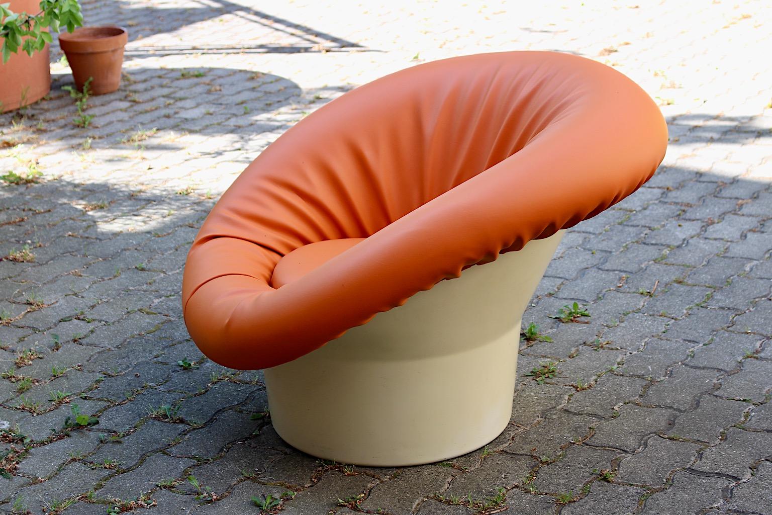 Fauteuil de salon ou fauteuil club de l'ère spatiale en plastique blanc et faux cuir orange conçu et fabriqué en France dans les années 1960.
Le design est très similaire à celui de la chaise champignon de Pierre Paulin et provient de la même