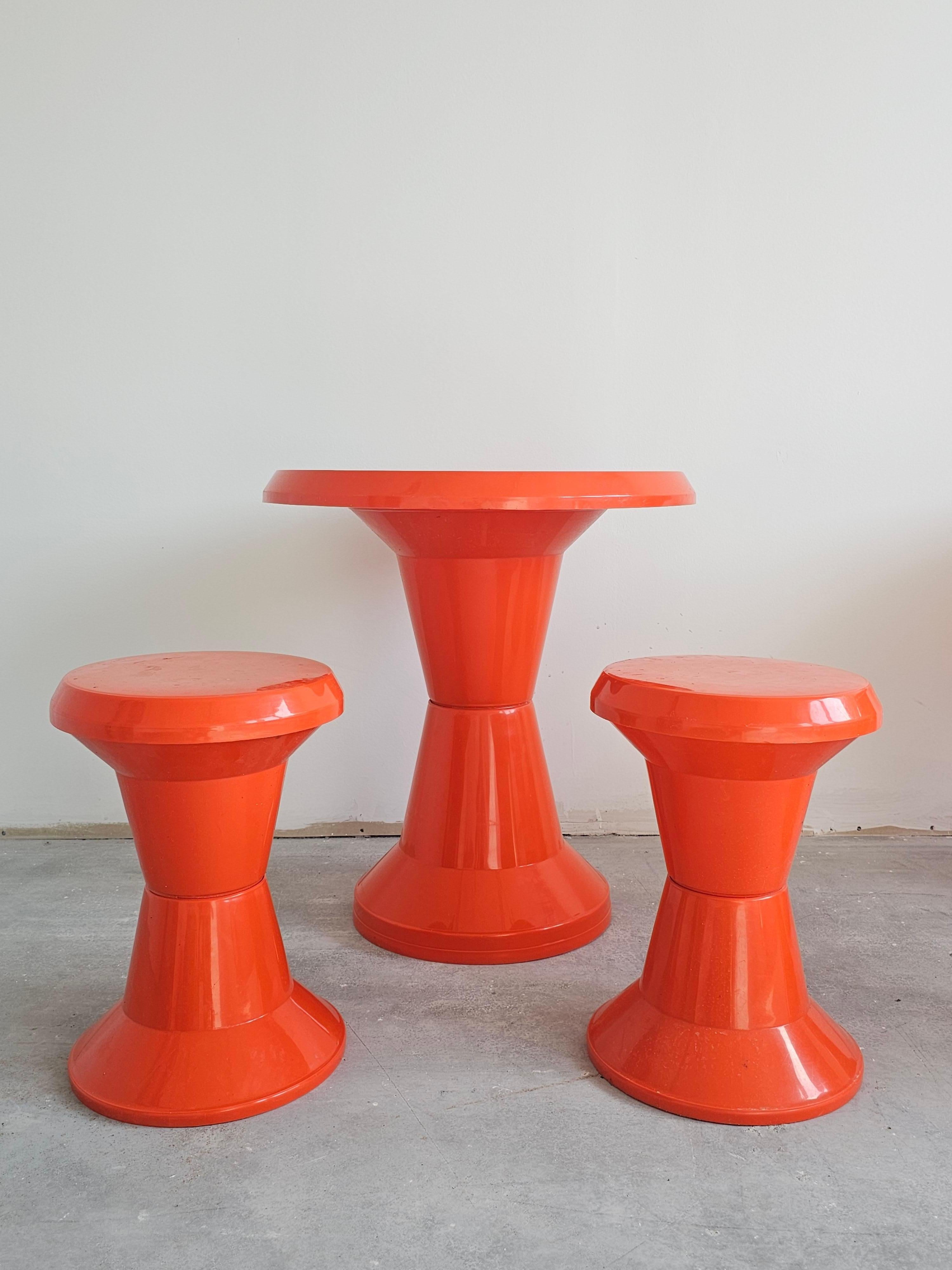 En este anuncio encontrarás un rarísimo juego de jardín de la Era Espacial compuesto por una mesa y dos taburetes de bar. Todo el conjunto está hecho de plástico naranja y fabricado por Kovinoplastika. Tanto los taburetes como la mesa son fáciles de