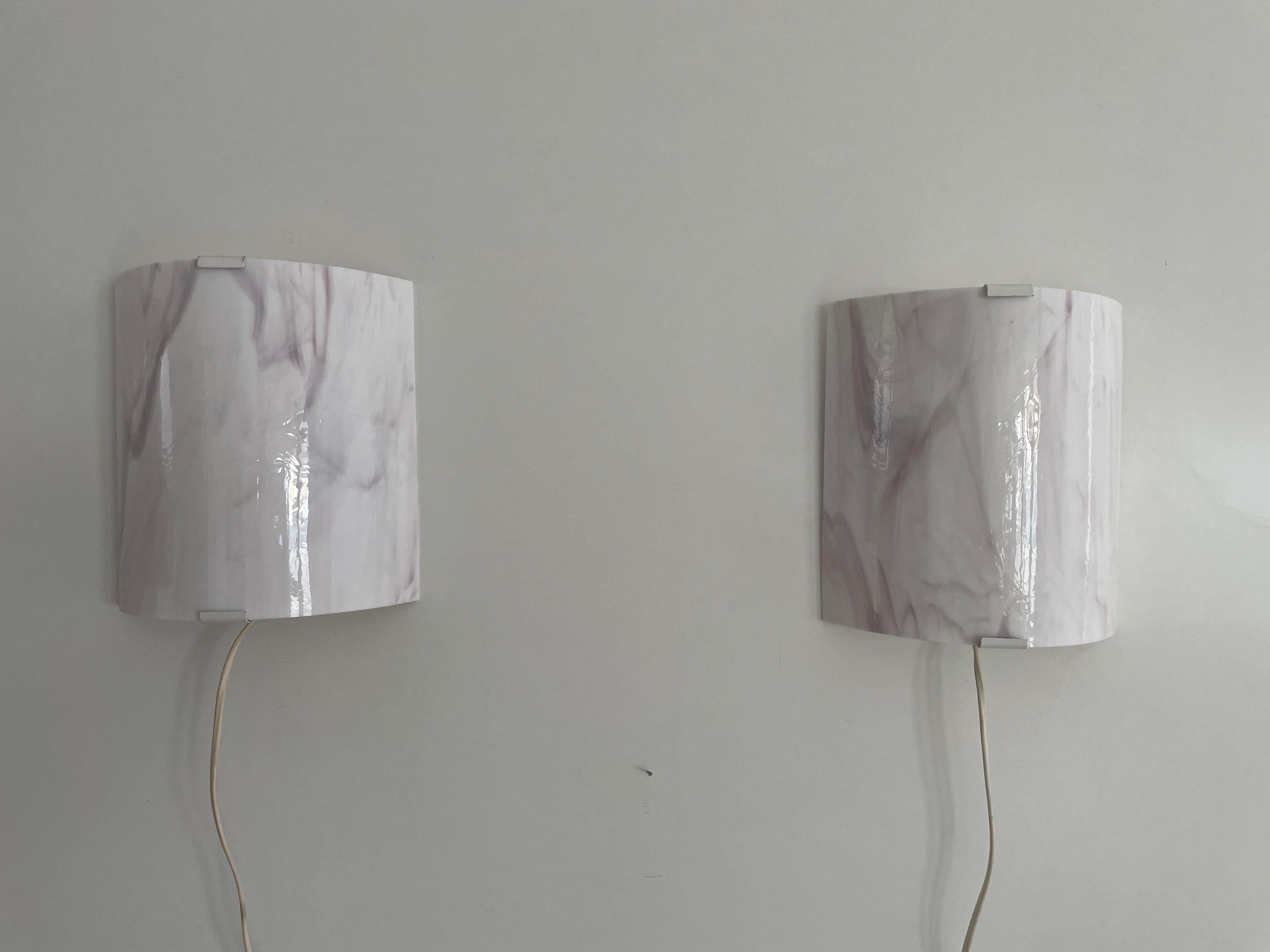 Space Age Pink Glass Pair of Wall Sconces, 1970s, Germany

Elegant rare high quality wall lamps.

Lamps are in very good vintage condition.
Wear consistent with age and use

These lamps works with E14 standard light bulbs. 
Wired and suitable to use
