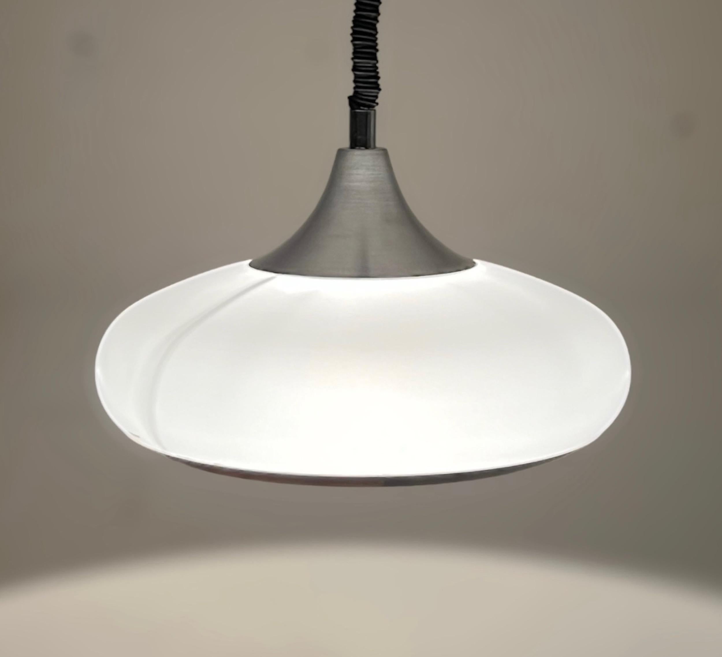 Iconic 70s space age pendant lamp made by Stilux Milano. This lamp is made of a conic silver metal top, that supports a big, curved white polymethacrylate lampshade.

The latch mechanism is the famous “Rolly”, made in Italy in the 70s. The extension