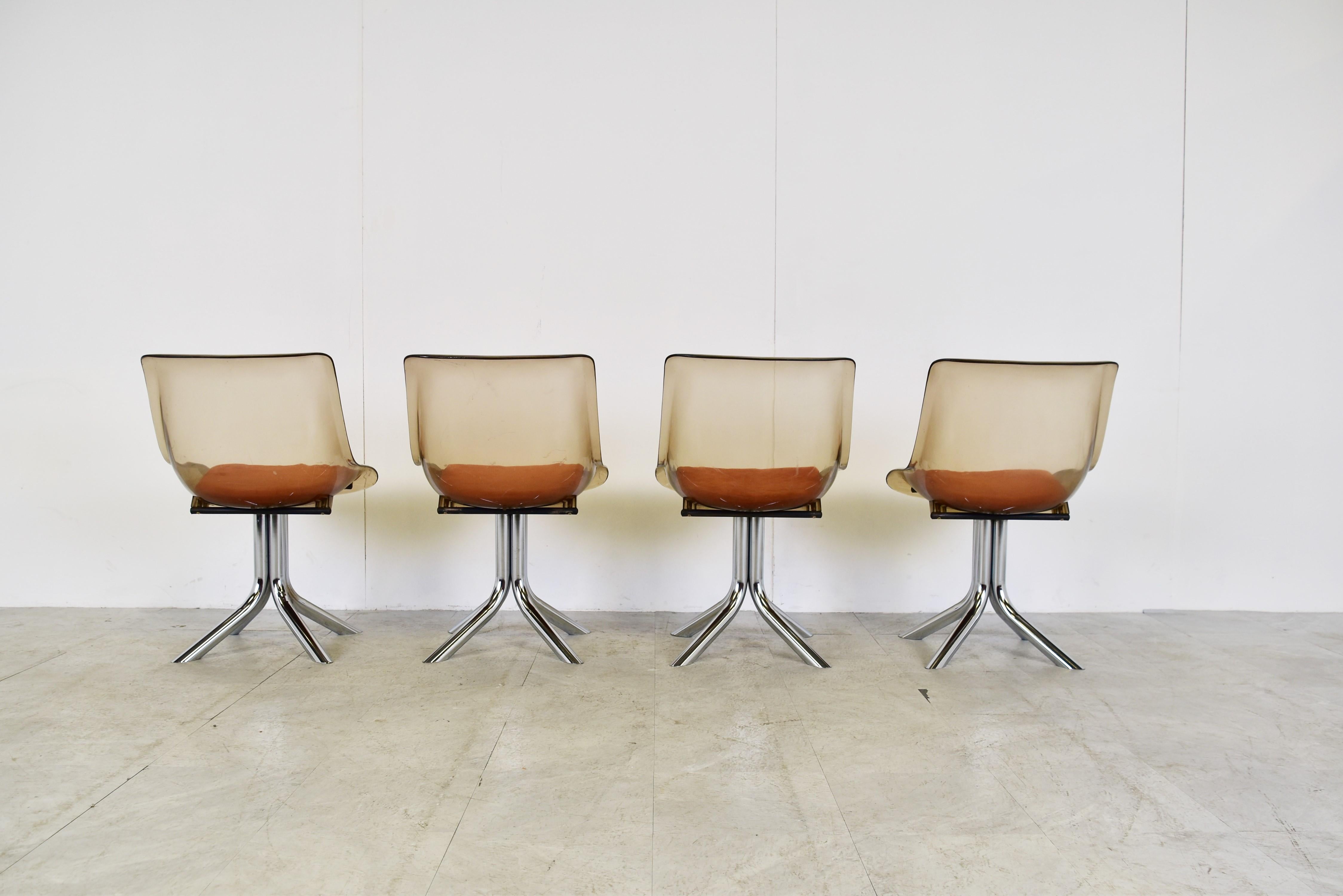 Mid century space age design dining chairs on a chromed tubular base with smoked plexiglass seats and orange fabric cushions.

Beautiful vintage design.

Good condition with normal age related wear

1970s, Italy

Dimensions:

Height: