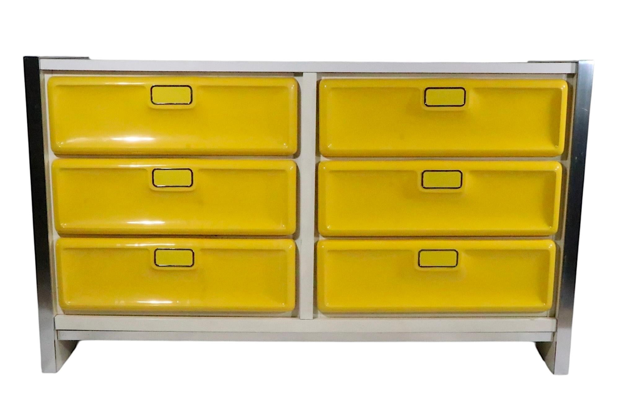 Cool Space Age, Mid Century, Post Modern six drawer dresser, having bright yellow plastic drawer fronts with  brushed metal sides and a white formica top. Made in the USA, by Bassett circa 1970's, after Raymond Lowey. 
 This example is in very good,