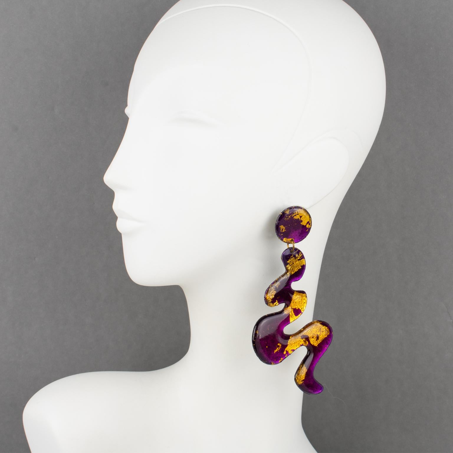 These stunning Italian Resin or Lucite dangling pierced earrings feature an oversized chandelier shape with a freeform zig-zag design in amethyst purple color with gold leaf application. The purple color has a mirrored textured pattern on a black