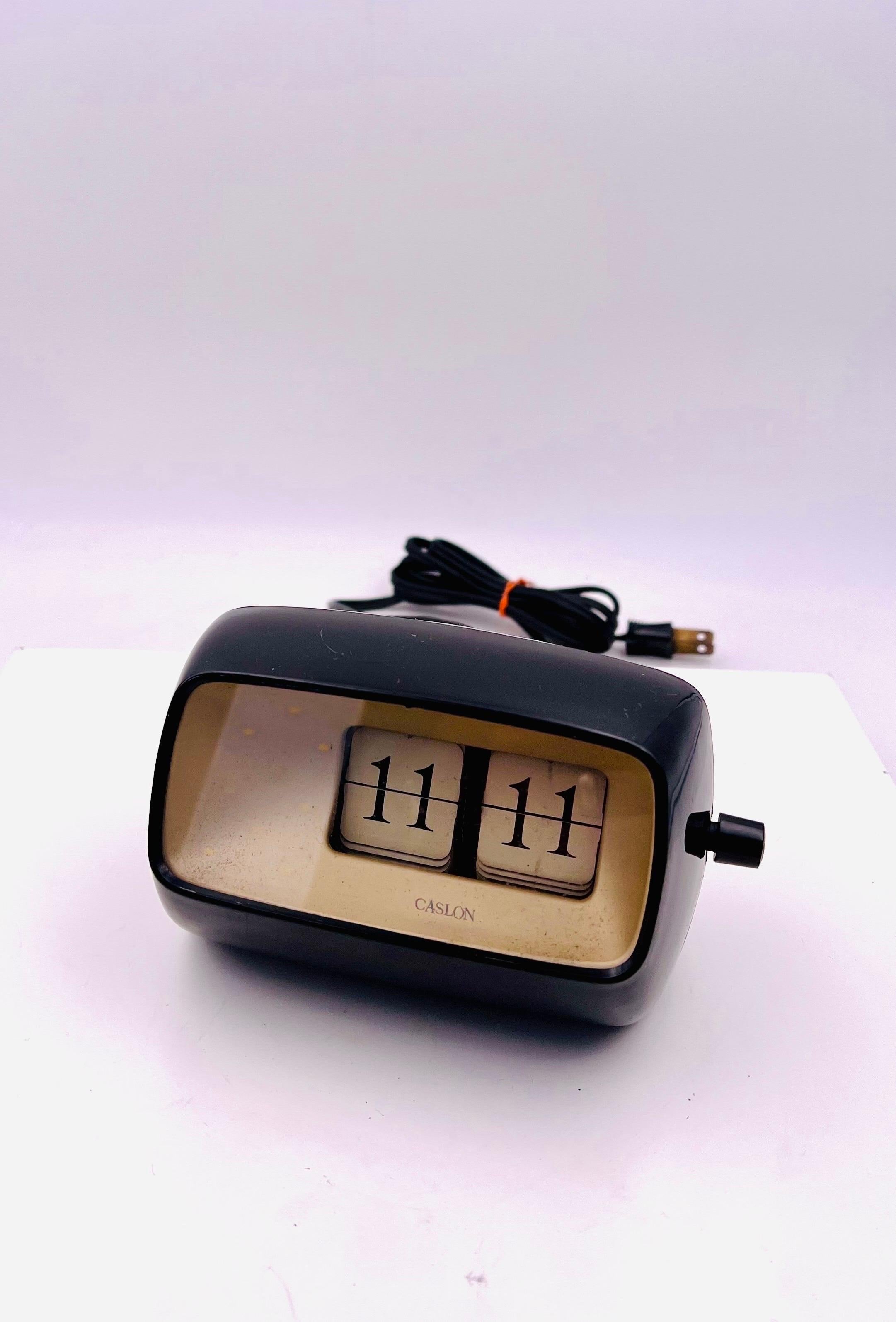 Simple and rare Caslon flip desk table top electric clock black plastic case with glass visor, circa 1970's in perfect working condition.