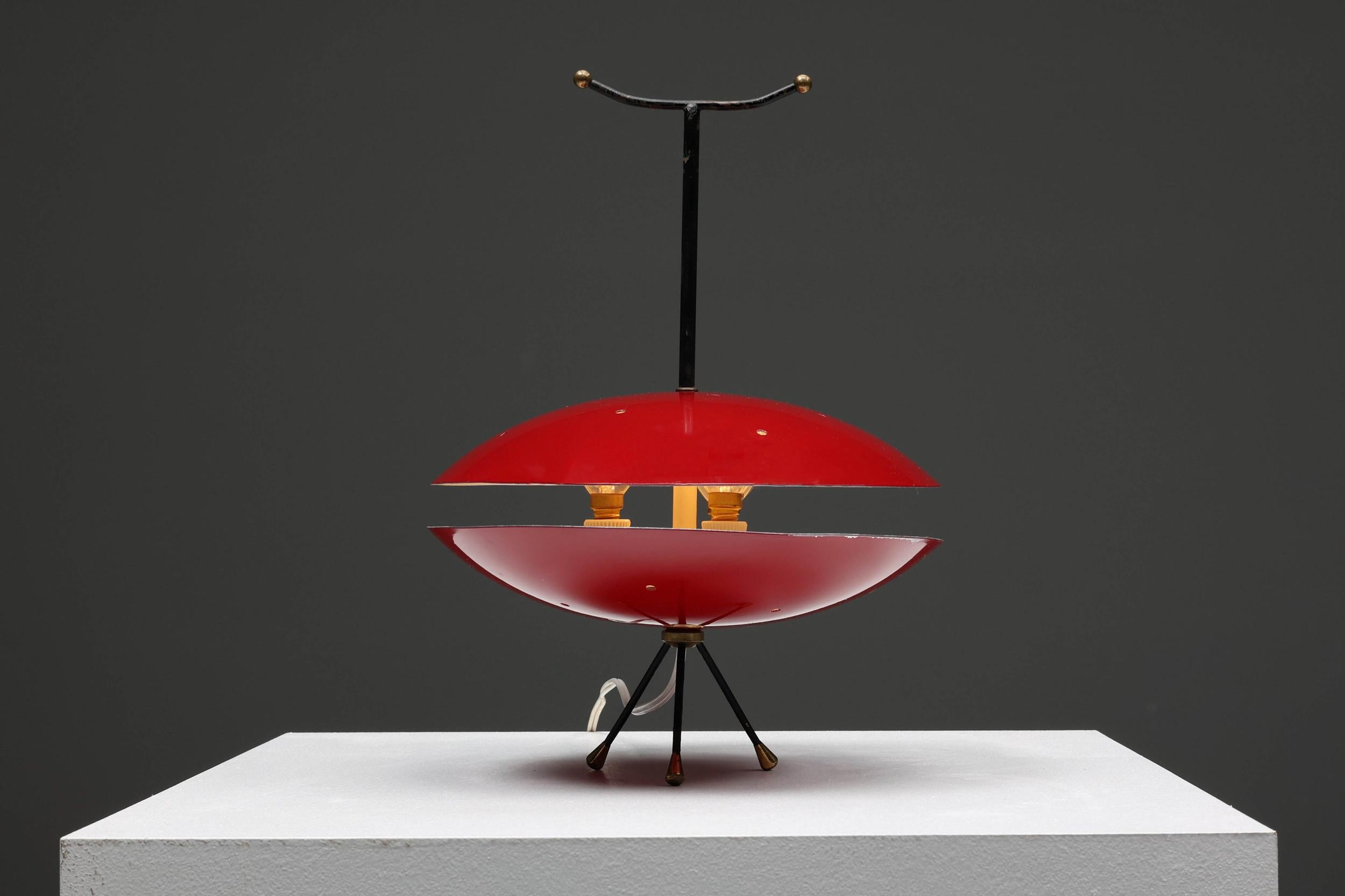 Space age; red & black; Italian design; floor lamp; table lamp; light; 

Space Age red & black lamp. Could serve as a floor lamp or table lamp. Has a remarkable detail of brass dipped feet. The light escapes between two red organic parts.