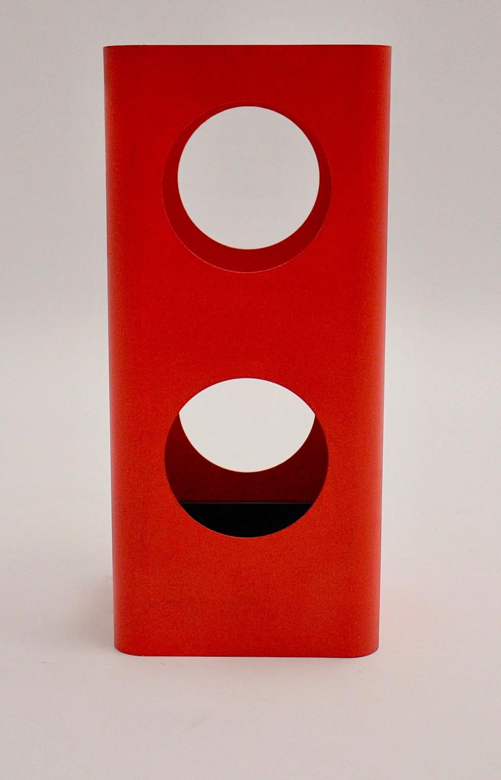 Dieser Weltraumzeitalter-Schirmständer aus rotem Metall wurde um 1970 in Österreich entworfen und hergestellt.
Der Schirmständer hat runde Löcher als Dekoration und ist neu rot lackiert.
Außerdem hat der rote Schirmständer eine lose schwarze