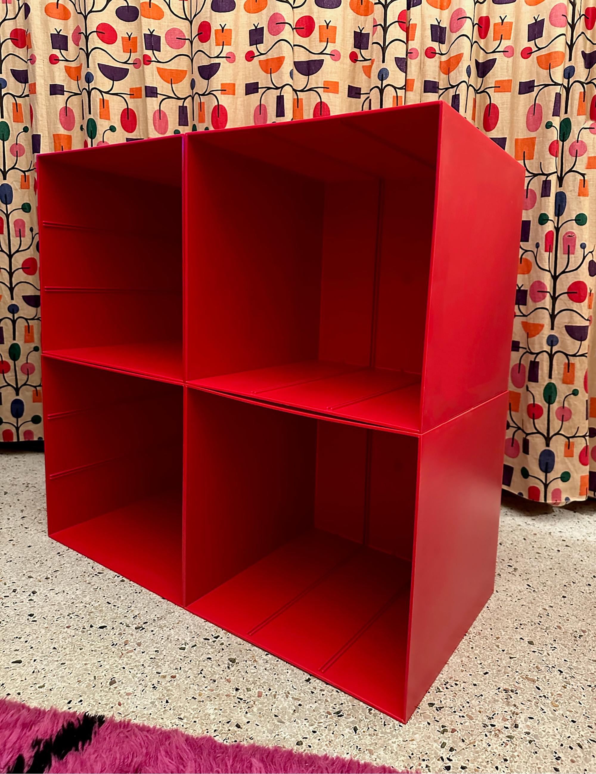 This vintage space-age red plastic cube modular shelving system, dating from the 1970s-80s, is a stylish and functional piece of furniture. Made of hard plastic this original set includes four cubes that can be used for record, book storage or