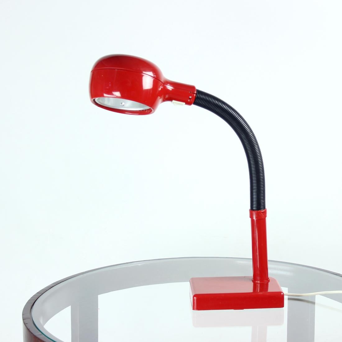 Great table lamp with design very typical for the midcentury era. Produced in 1960s in Hungary by Szarvasi Vas company, original label on the bottom (pictures). The lamp is made of red and black combination of plastic. The black part is a adjustable