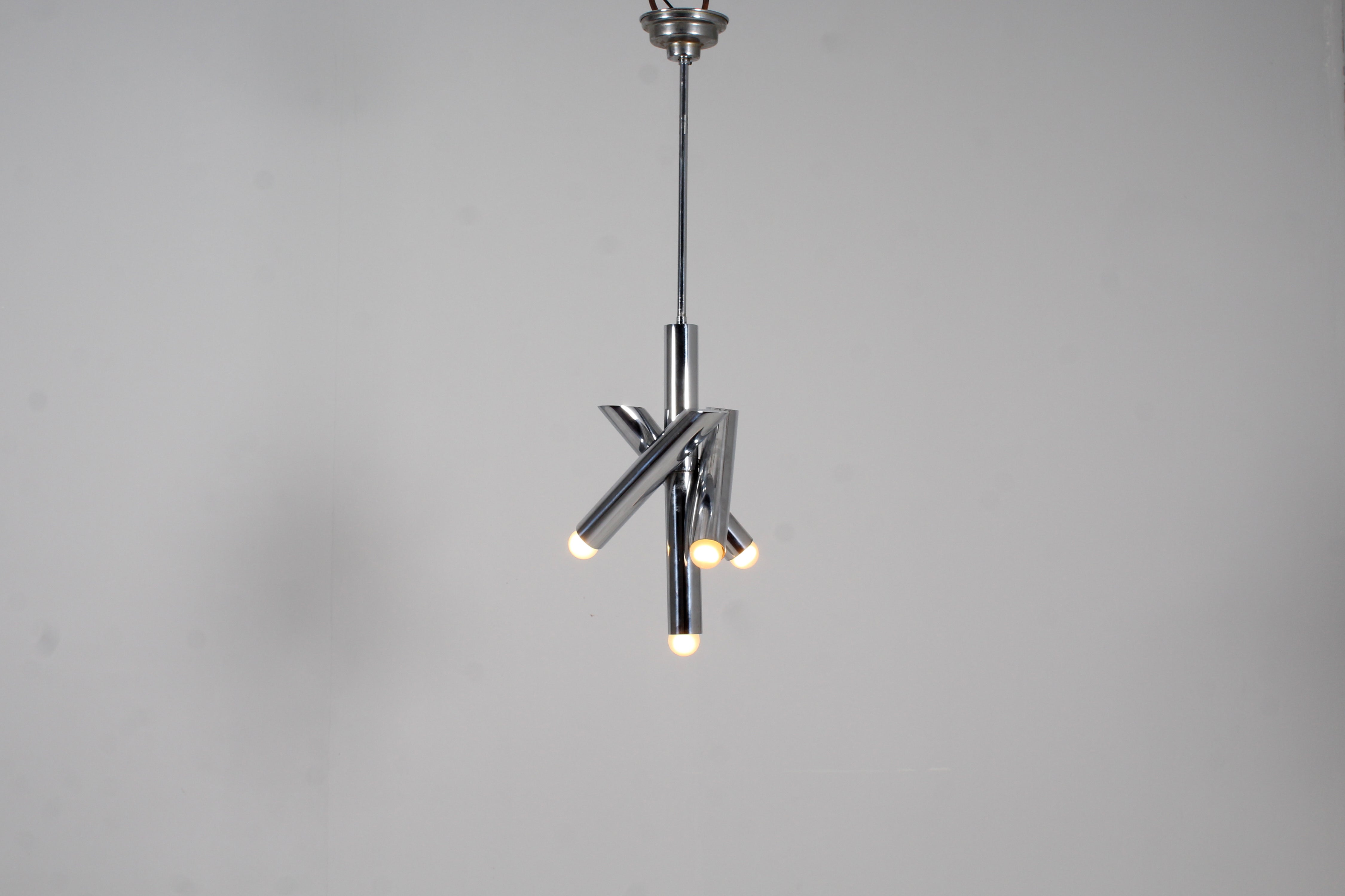 Captivating Space Age suspension lamp in chromed steel tubes with four lights, with three adjustable spots on a fixed central cylindrical body. Attributable to Reggiani, Italian production in the 70s
Wear consistent with age and use.