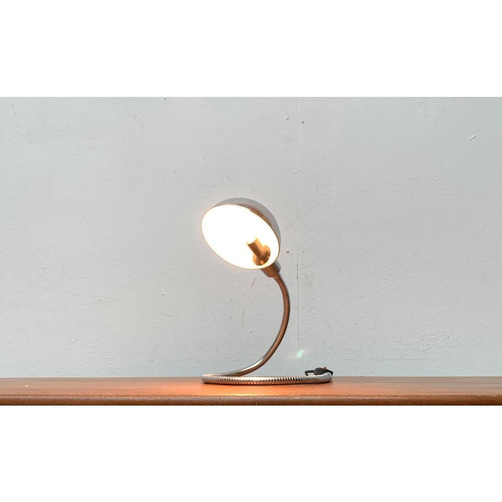 Space Age Snake Lamp in chrome.

A classic from the 60/70s. The lamp is adjustable in almost every position via the characteristic tube arm. The umbrella is rotatable. In contrast to the most famous Snake Lamp, the Hebi valti, this is designed with