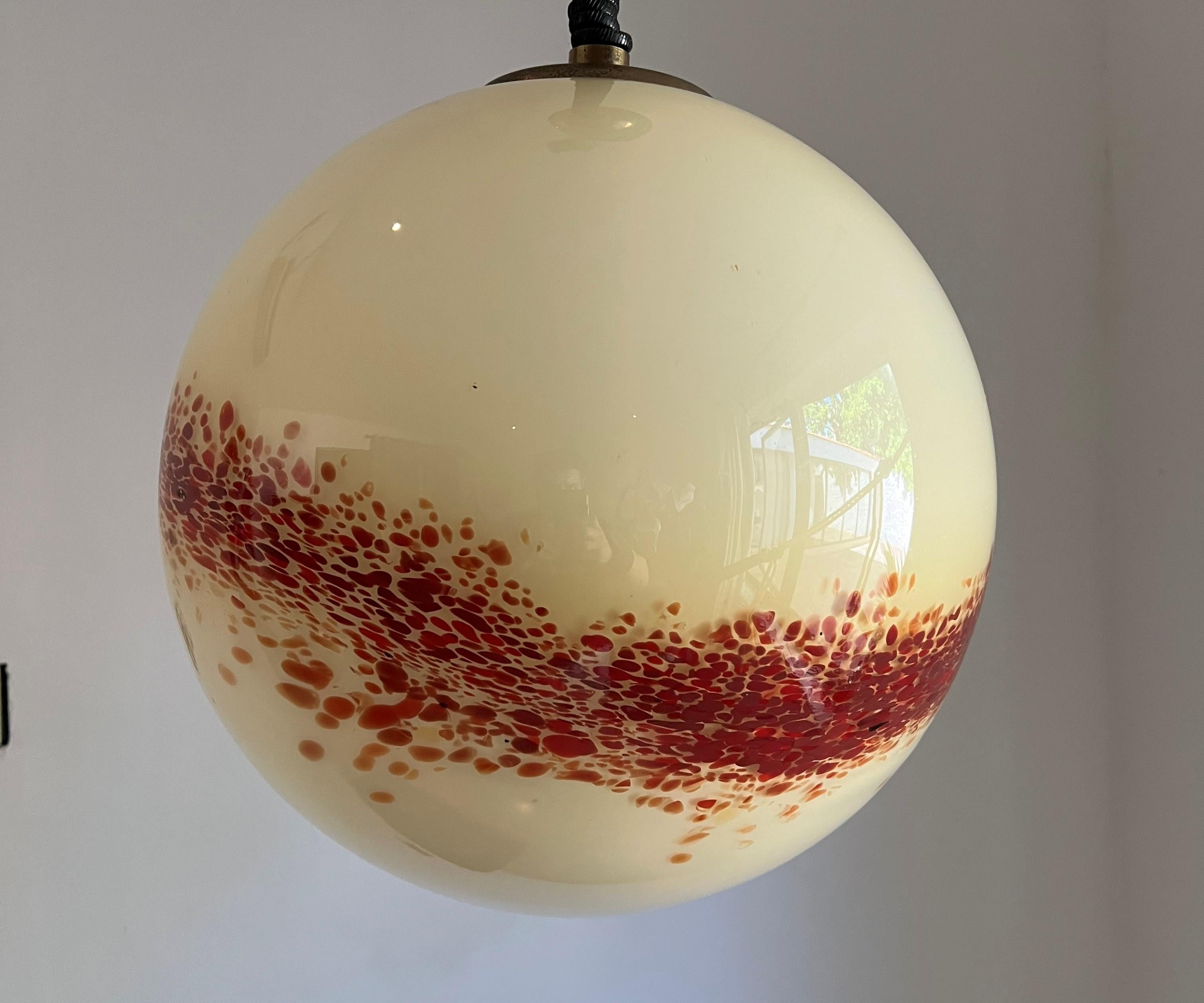 Space Age pendant light manufactured in cream and orange mottled hand blown Murano glass, in the style of Mazzega, circa 1970.
This sphere is 41 cm in Diameter.
It has its original coiled cable, we ran a new electric cord through it, it can easily