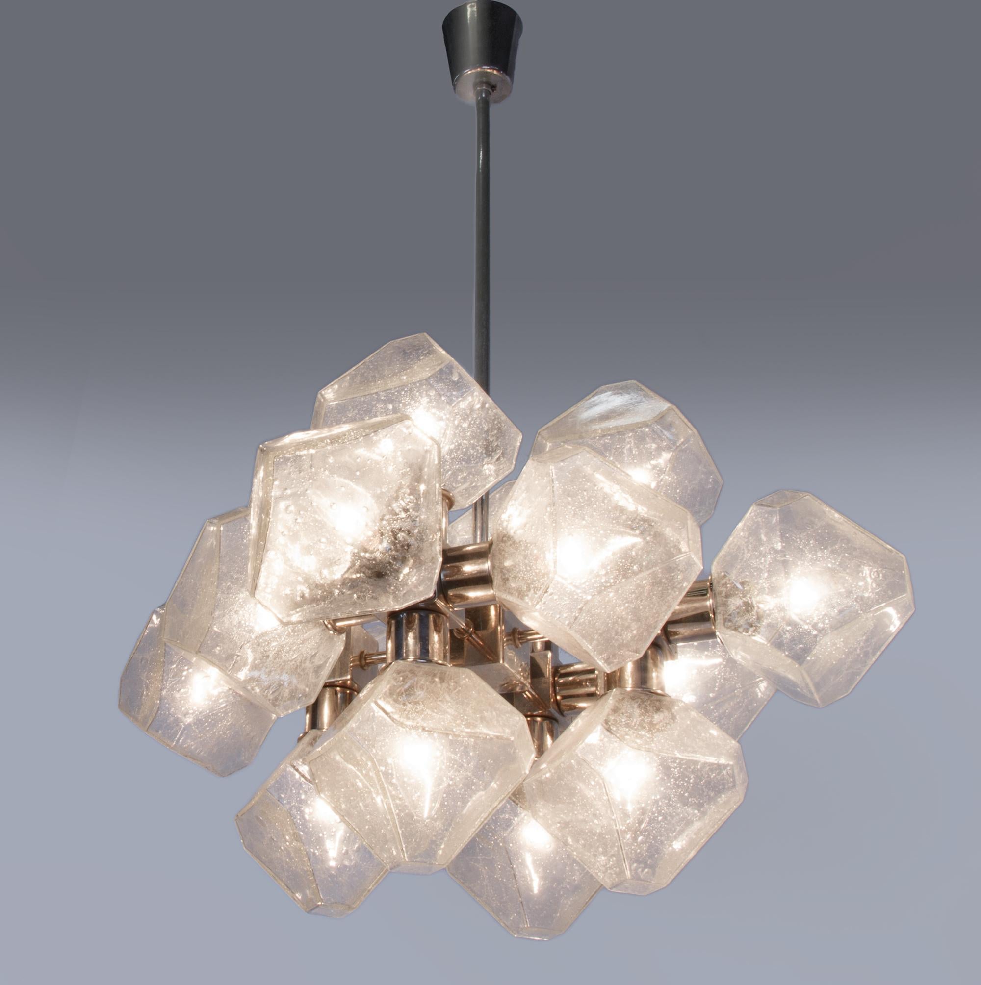 Elegant high quality chandelier with 16 cubist glass bodies on a chromed frame. The chandelier is made of chrome-plated metal and very nicely shaped glass. The clear glass has small air inclusions. Gem from the time. With this light you make a clear