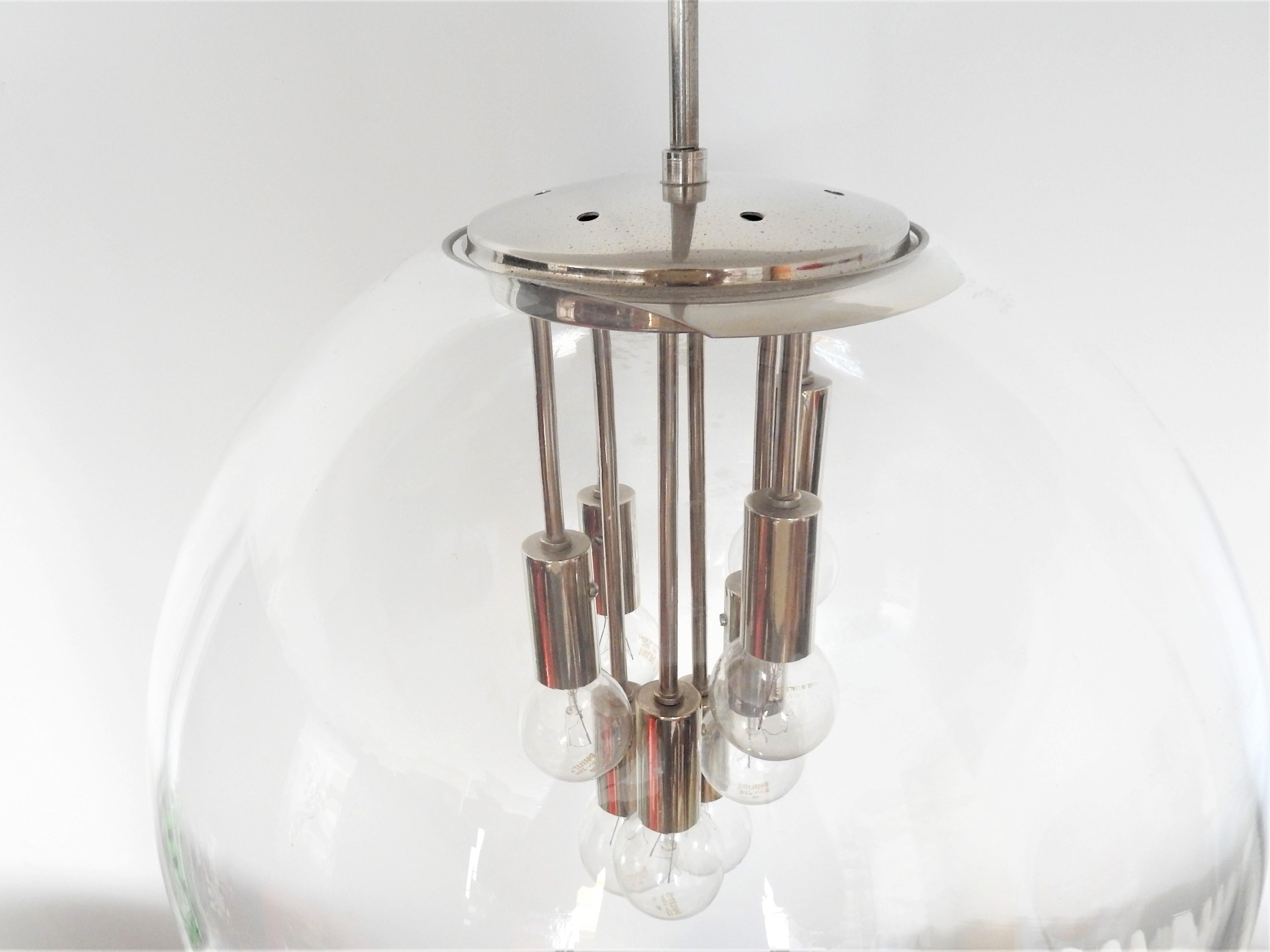 This is an impressive Space Age globe pendant lamp from the 1960s-1970s. The globe is made of a blown glass globe and a chromed metal part with 8 chrome plated E14 fittings on the inside, in a playful setting. This lamp looks very much like the