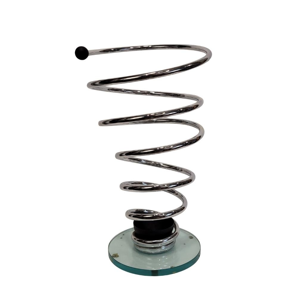 A playful and very fun  spiral umbrella stand, designed in the Italian style of the 1980s, in a mid-century style. The piece is structured around a dynamic chrome-plated steel spiral rising from a circular glass base. This contrast between the