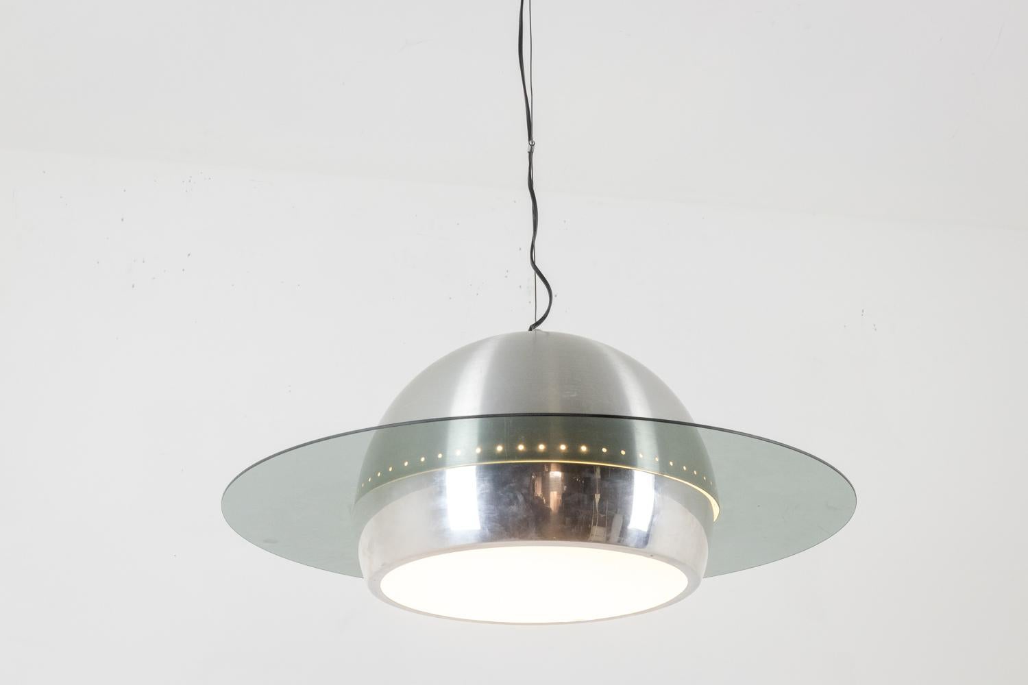 Lampada a sospensione in metallo lucido e spazzolato, decorata con un anello di vetro.

Opera italiana realizzata nel 1970 circa.

Dimensioni: H. H. 90 x D. 70 cm

Riferimento: LS6068508H