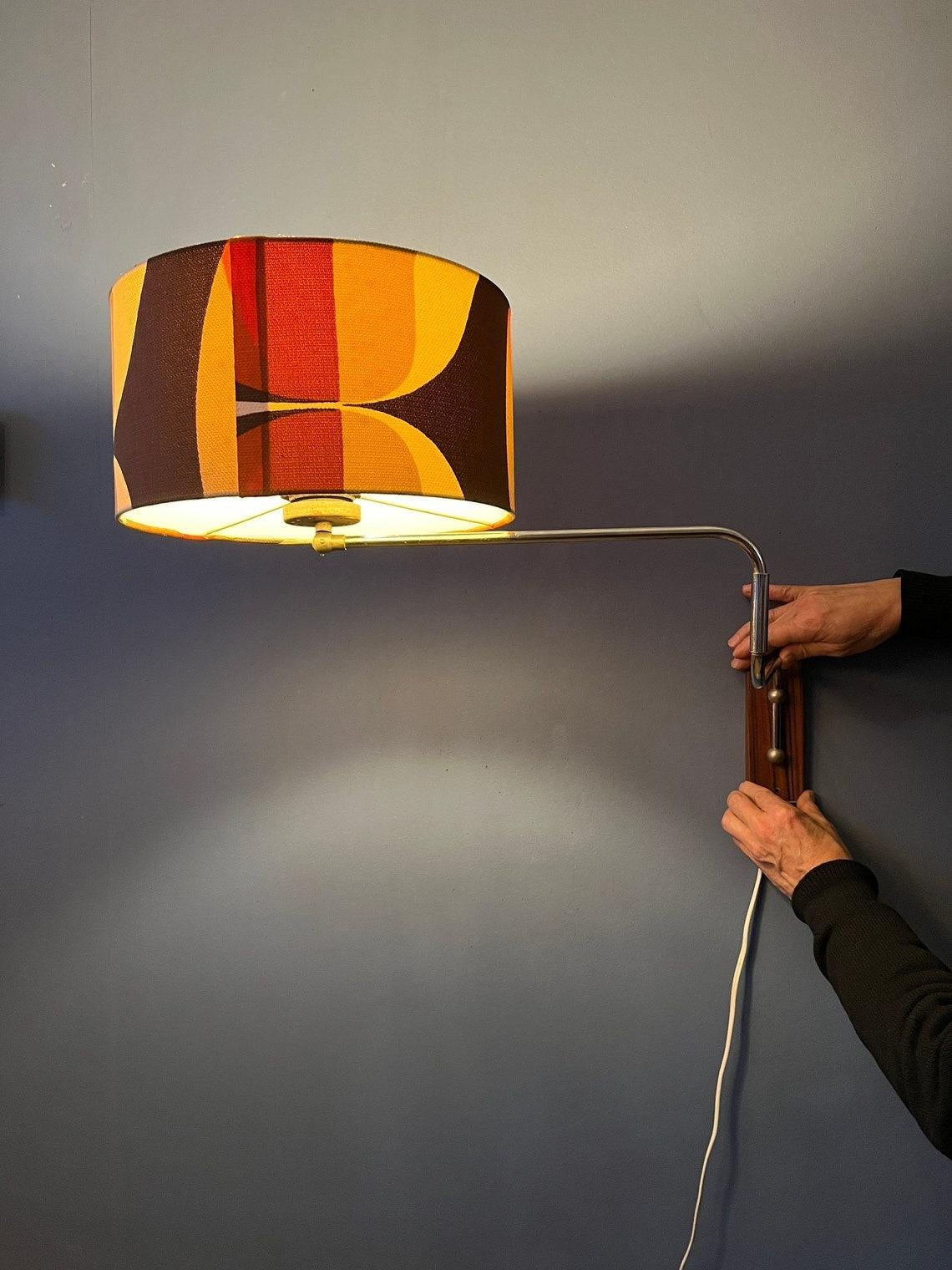 Space age swing-arm wall lamp with orange flower shade. The swing arm allows you to adjust the length of the lamp. Also the position of the shade can be adjusted. The lamp requires an E27 (standard) lightbulb and currently has an EU-plug (works