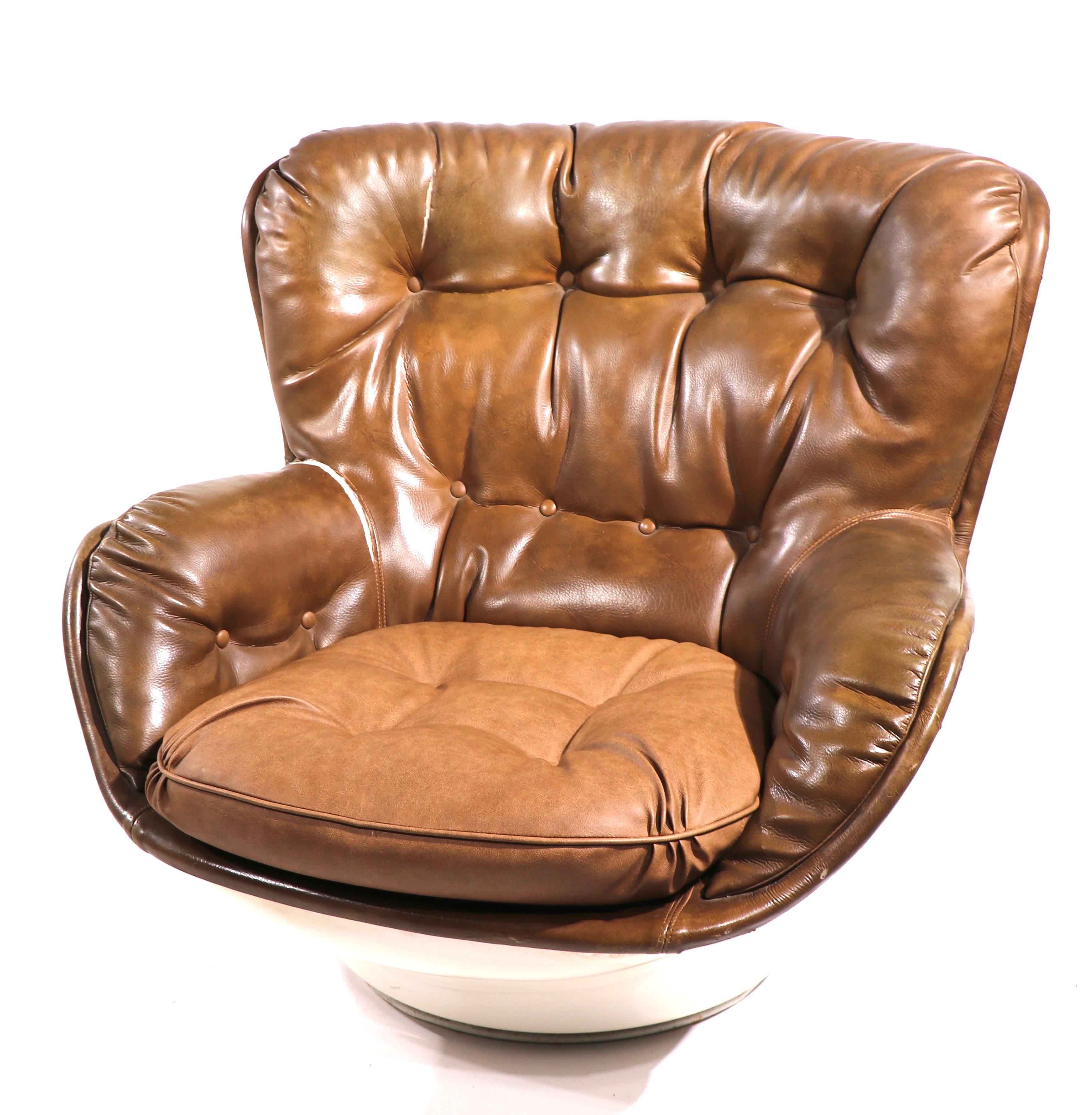 Very cool Space age swivel pod chair, having a white exterior shell, with upholstered interior seat, The white shell is fiberglass, the brown interior is vinyl. The vinyl upholstery has two splits, please see images. The chair is marked Charlton