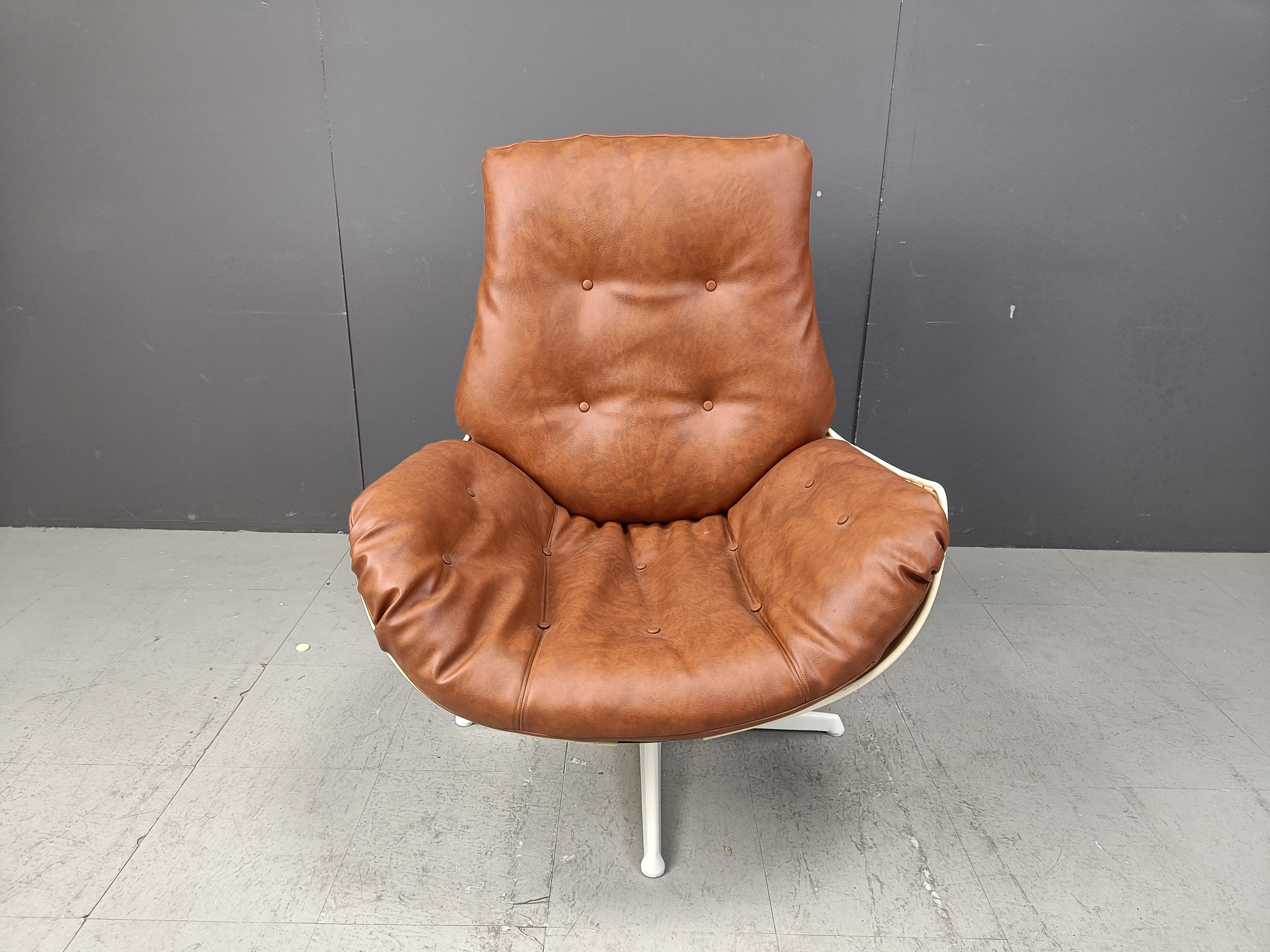 Sedia girevole a guscio in fibra di vetro con cuscini in pelle marrone e base in metallo laccato bianco.

Fantastico design dell'era spaziale.

Anni '60 - Germania

Dimensioni:
Altezza: 100 cm
Larghezza: 75 cm
Profondità: 70 cm
Altezza della