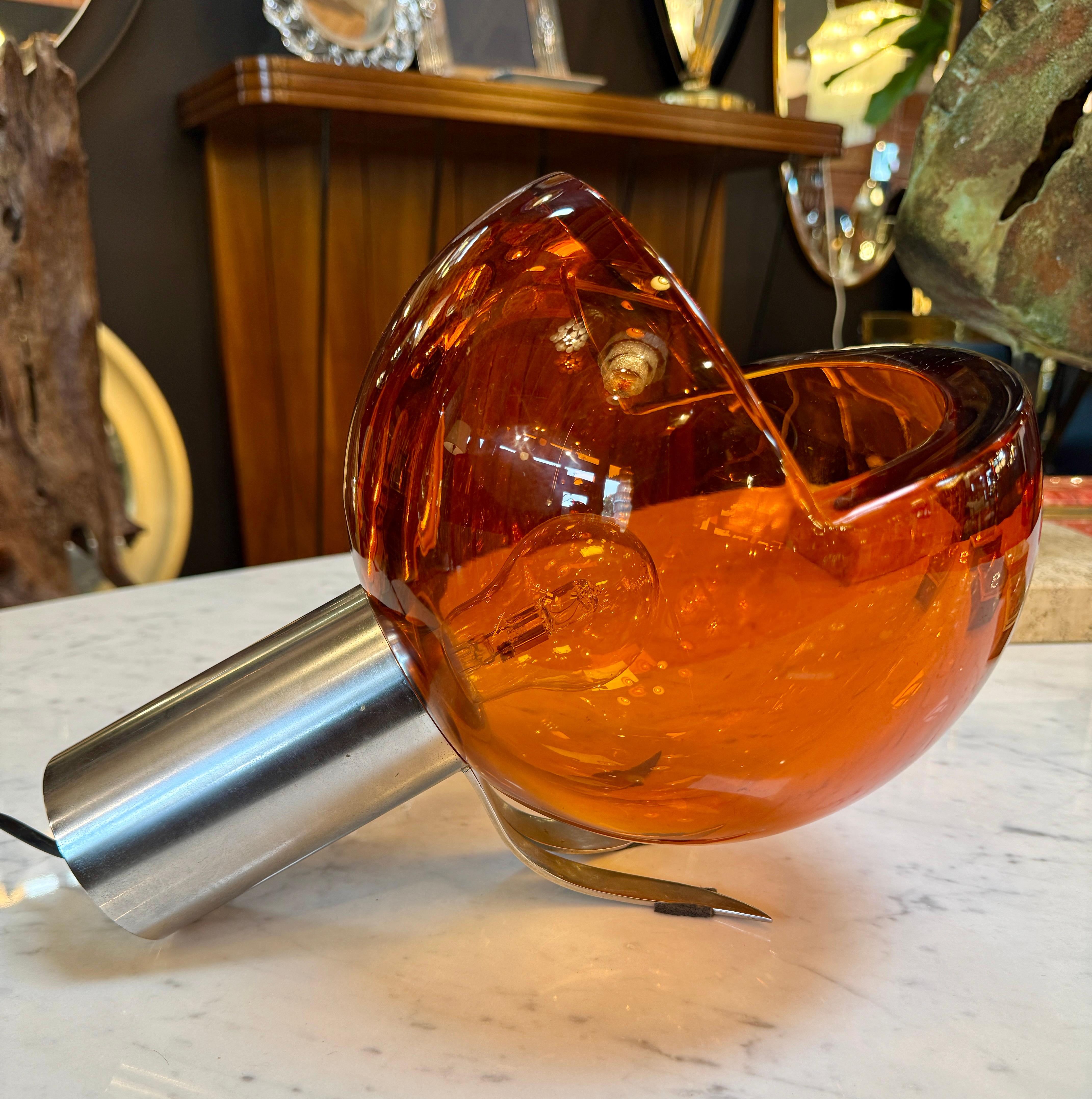 Un'audace e scultorea lampada da tavolo A Space Age di Flavio Poli, circa anni '70, proveniente dall'Italia. Il design è caratterizzato da un sorprendente globo di vetro di Murano color ambra, profondamente tagliato per rivelare una cavità interna