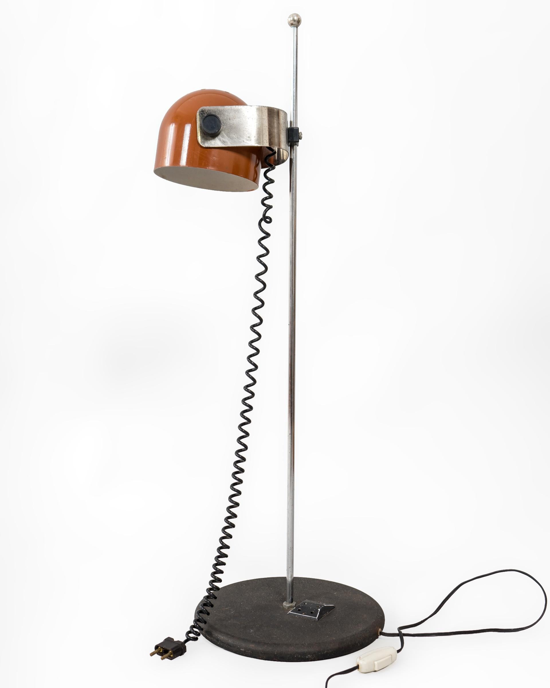 Lámpara de mesa italiana de los años 1960’s. Claramente influenciada por la era espacial de la época, ofrece un diseño y funcionalidad muy especial. El foco orientable y lacado en color miel se ancla sobre una pieza metálica que se regula en altura