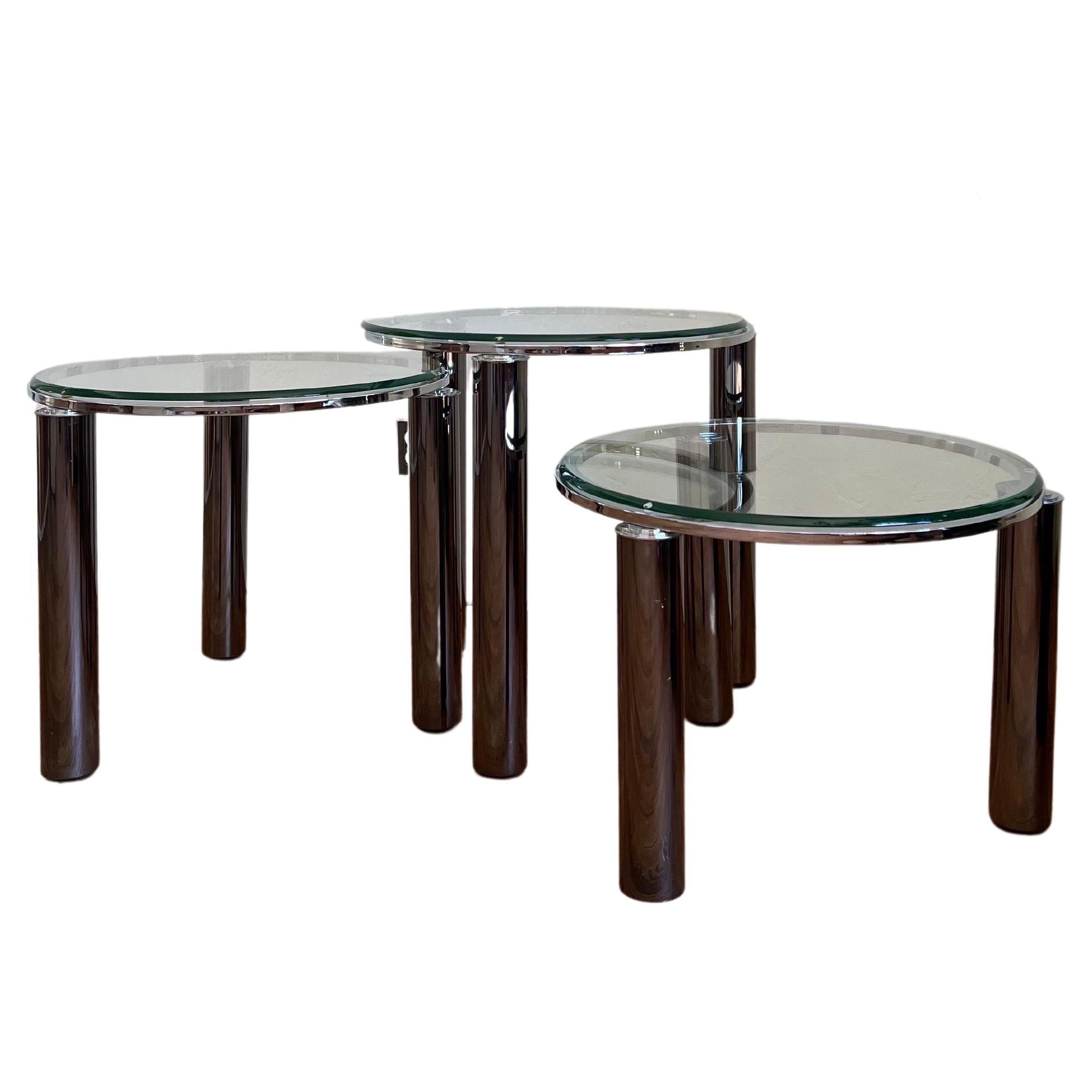 Set of 3 space-age Italian sculptural nesting tables featuring chrome frames with chunky tubular legs and glass tops. All three tables are on casters, which makes it easy to re-configure as you wish. Very sleek and modern.

Measures: Large 24.5”