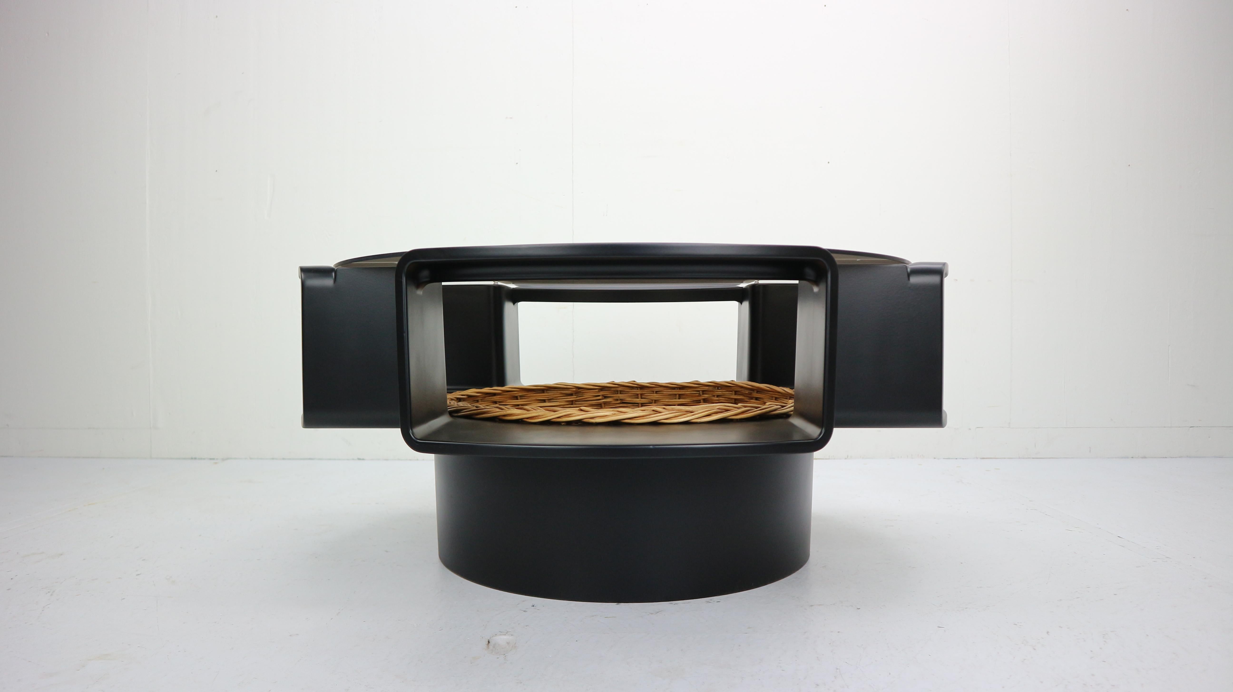 The table was designed by Curver-form and produced in Germany in the 1970s. 
This Ufo table is an extraordinary, Space Age period design peace. 

The table is made from black fiberglass and smoked glass top
In the middle of the base there is a