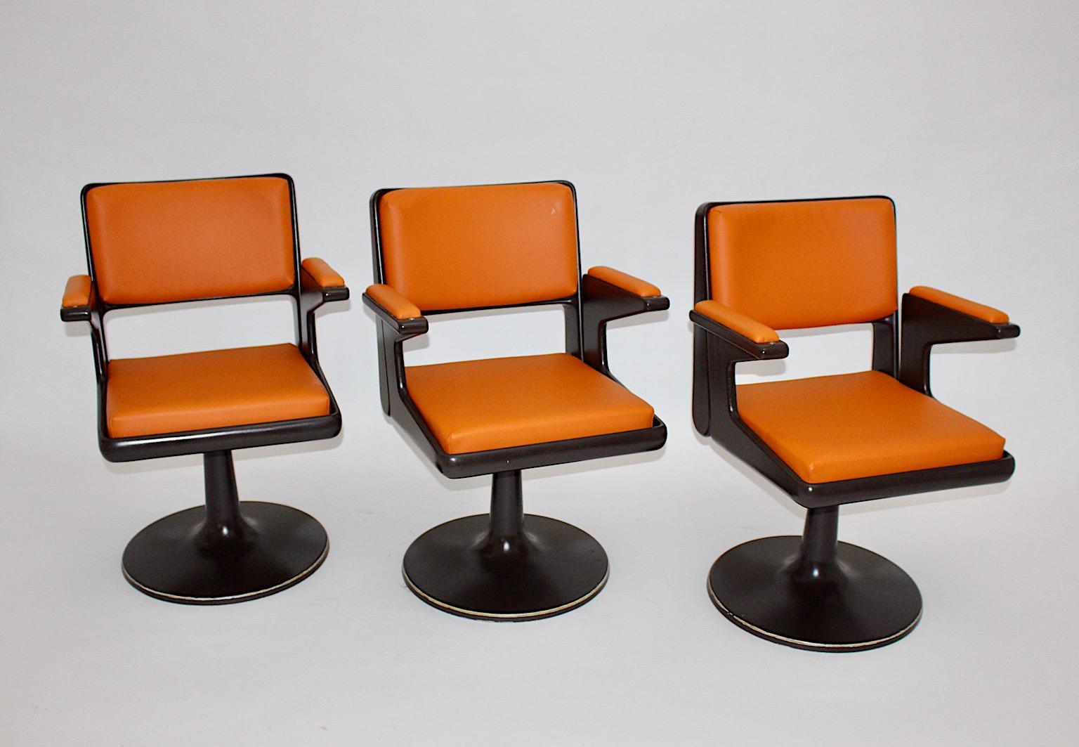 Space Age vintage swivel armchair from brown plastic and orange faux leather seats produced in Germany 1970s.
While the newly covered seats are in very good condition, the chocolate brown plastic seat frame shows signs of age and use like abrasions