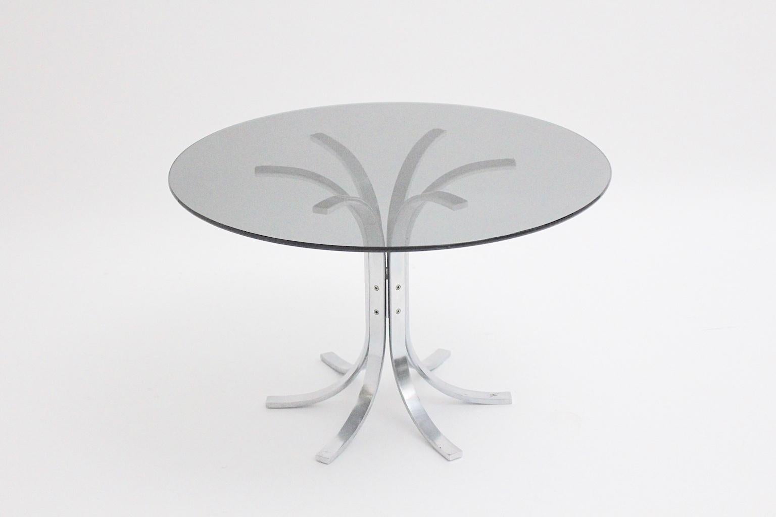 A Space Age chromed-plated metal coffee table by Merrow Associates, attributed circa 1970, which shows a smoked glass plate with approximate 80 cm diameter.
Furthermore the chrome-plated metal base shows 6 legs and an approximate height of 50.5