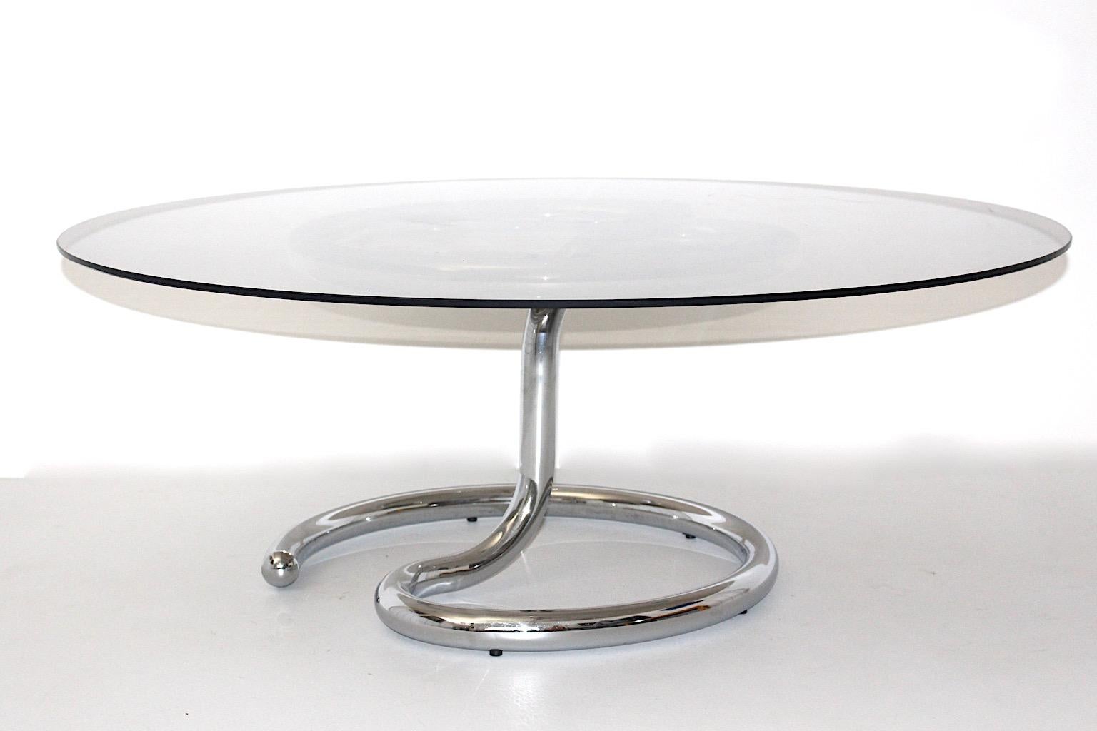 Space Age vintage coffee table from chromed metal and smoked glass 1970s Germany.
While the chromed metal base shows a beautiful curved construction, the smoked glass top features round shape.
Very good condition with signs of age and