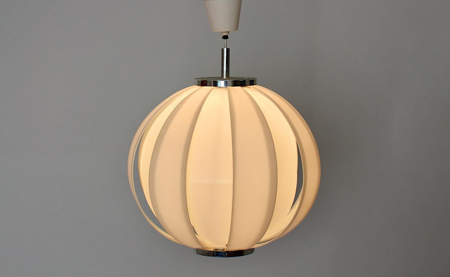 Space Age vintage circular like chandelier or pendant from white plastic lamellas and metal 1970s.
An amazing chandelier or ceiling light from plastic in white color with metal in circular shape. The lamp shade consists of 16 white plastic leaves
