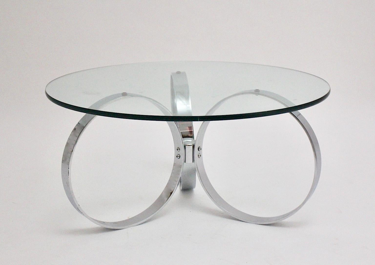 space Age Vintage Couchtisch / Sofatisch, die eine verchromte Basis mit drei Ringen gebildet zeigt. Eine klare Glasplatte krönt den Tisch, während das verchromte Metallgestell ein futuristisches Aussehen erzeugt. In den 1960er Jahren schätzten die