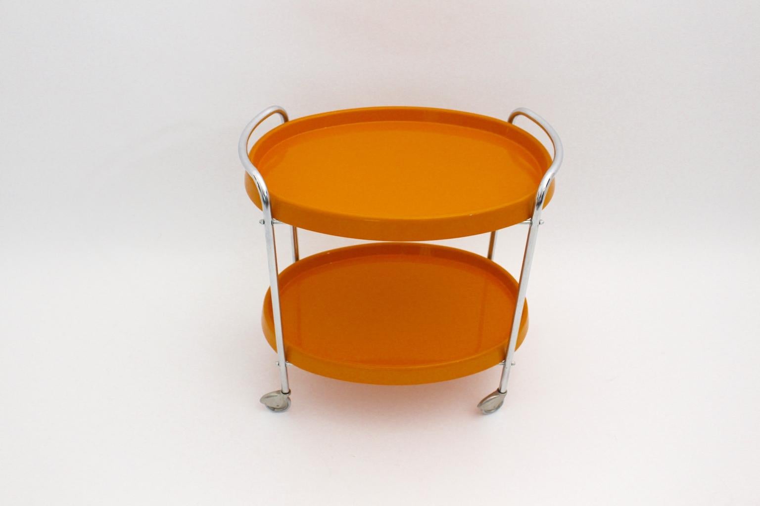The presented Space Age vintage bar cart from the 1960s shows a chromed tube steel frame and four wheels for mobility. Also the removable orange plastic trays show an oval shape.
The vintage condition is very good.
Approx. measures:
Width 65