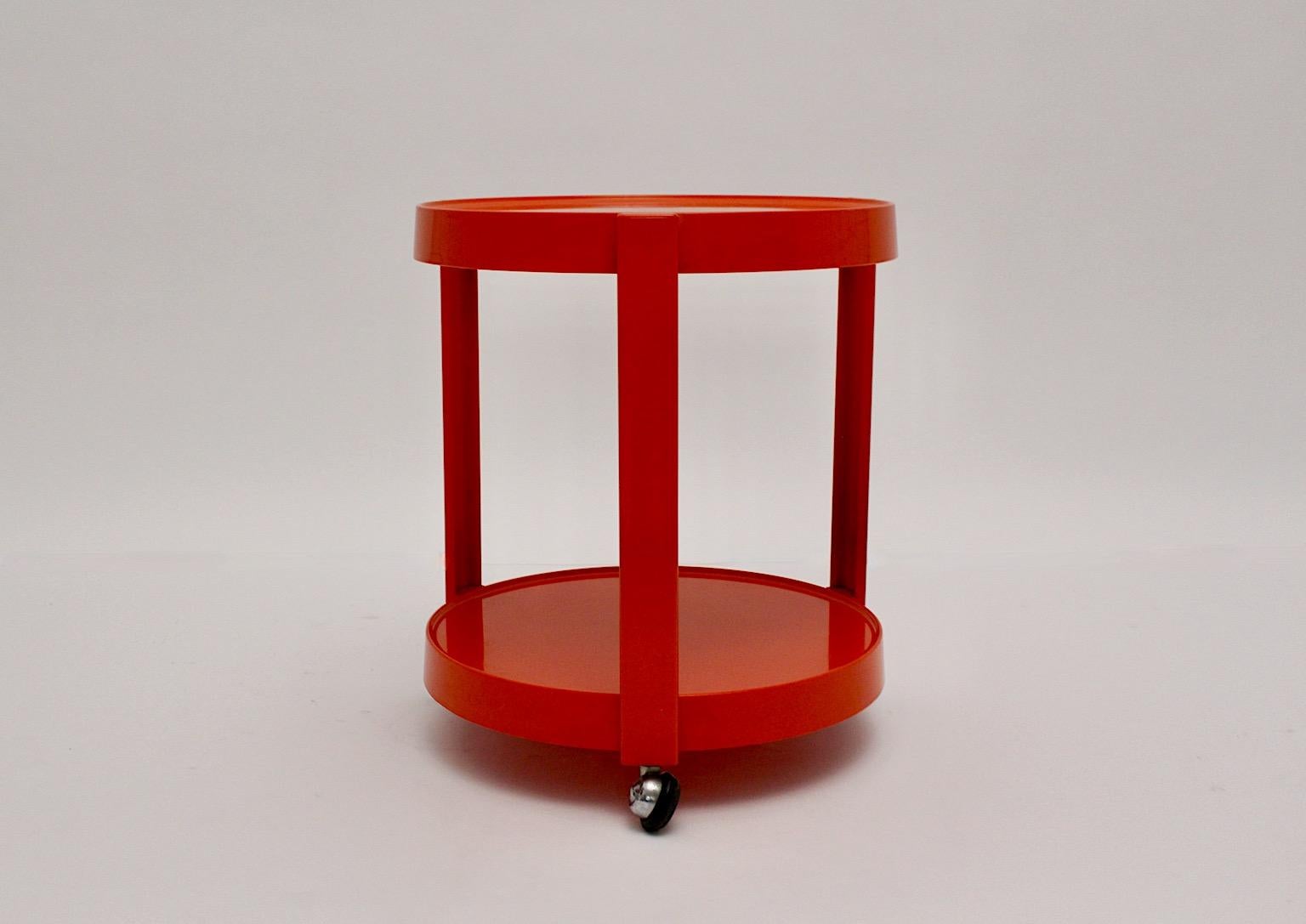 Space Age vintage red orange plastic bar cart or serving table or side table
1970s Germany.
A wonderful bar cart or serving table from plastic circular like with three connections between two tiers features wheels for a good mobility.
The boldly