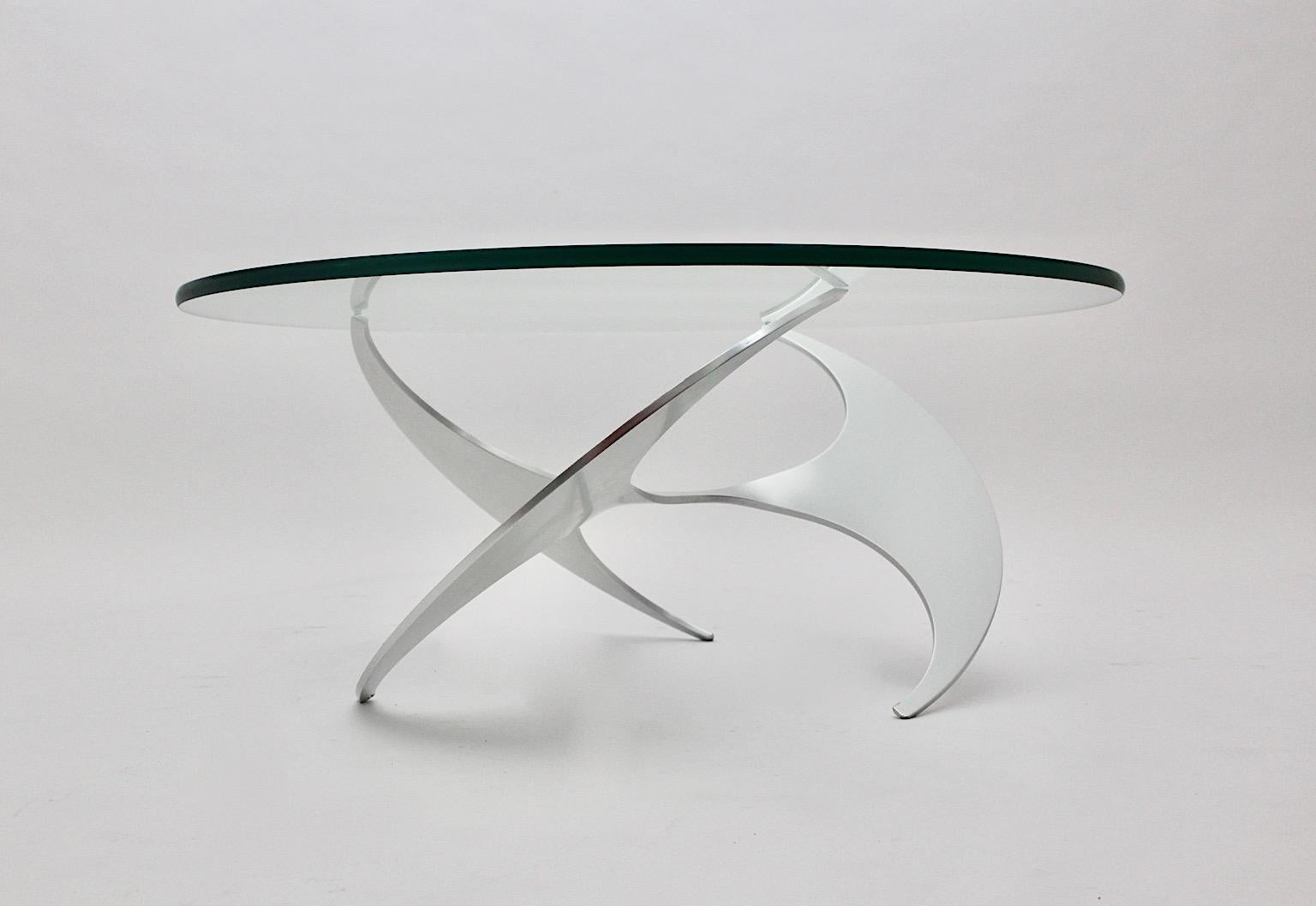 Ein Space Age Vintage Silber Aluminium Glas Couchtisch oder Sofa Tisch, der von Knut Hesterberg für Ronald Schmitt, ca. 1964, Deutschland entworfen wurde.
Während der polierte Aluminiumsockel eine großartig gedrehte Bewegung als Luftschraube zeigt,