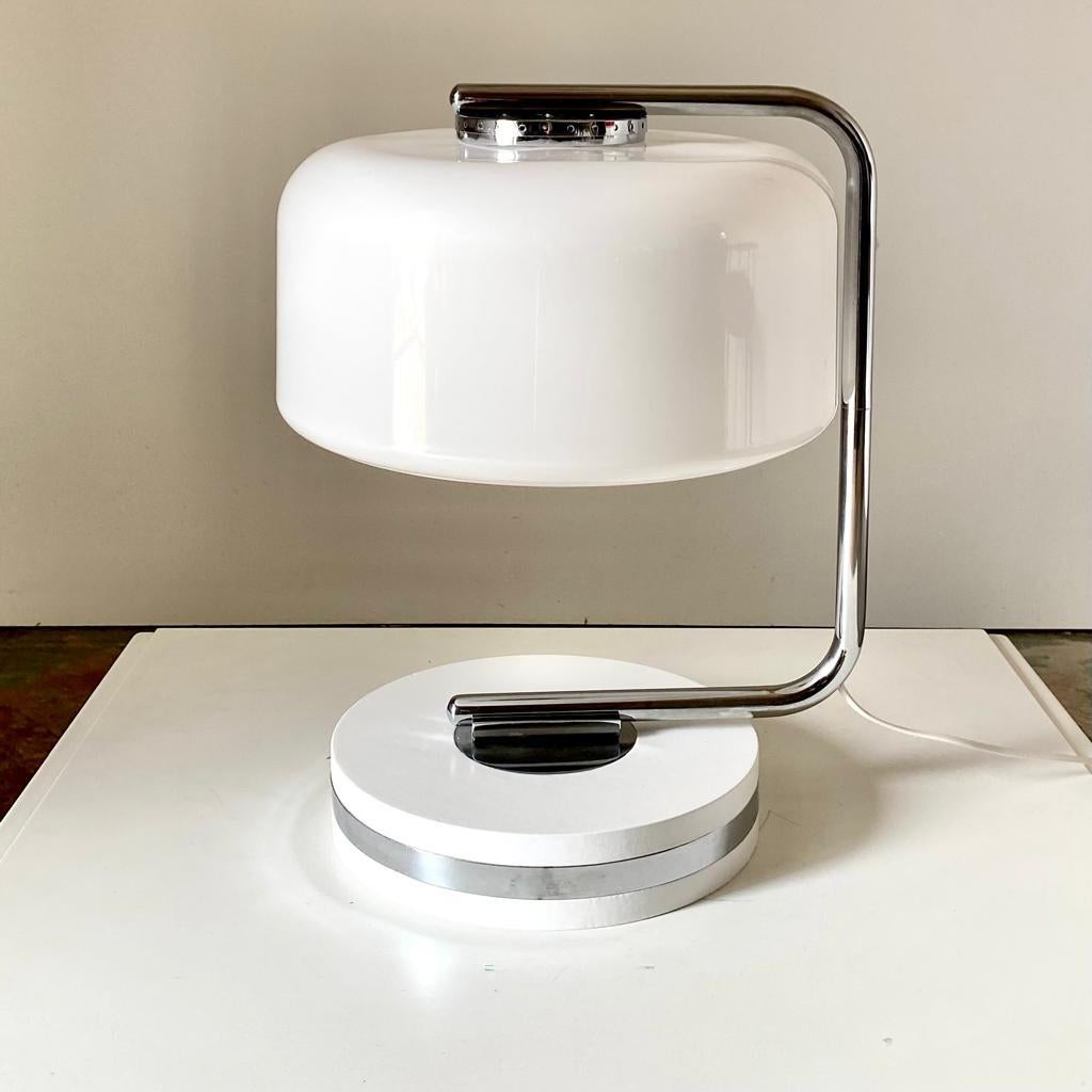 Italian design table lamp in the style of Guzzini. Manufactured in Italy in the 1970s and made of a travertine round base, adjustable chromed steel pole and a round plexiglass lampshade. 

Revised and polished, perfectly working , in good conditions