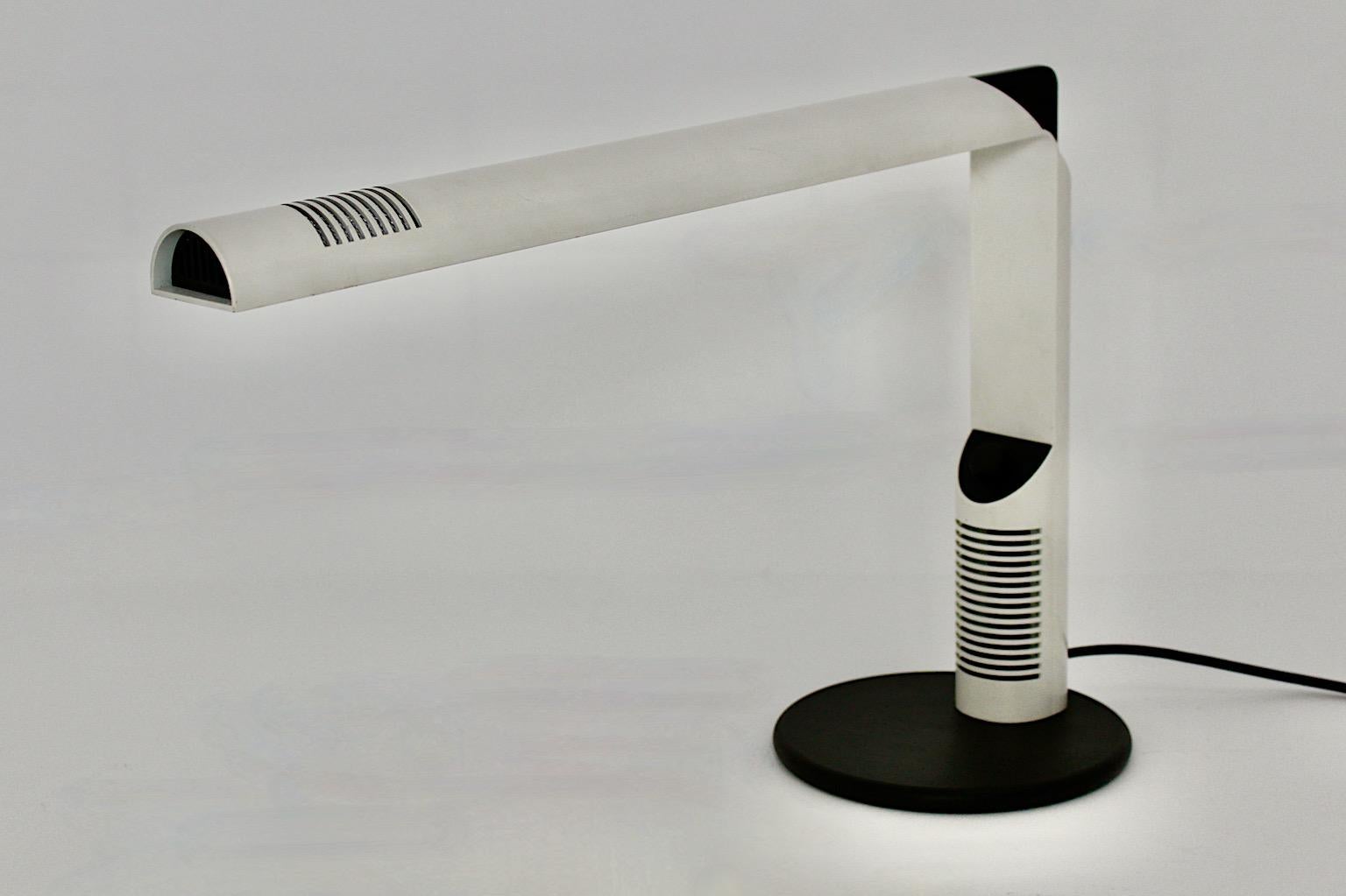 Space Age vintage white table lamp or desk lamp model Abele from white lacquered metal by Gianfranco Frattini for Luci Milan 1979.
The table lamp shows white lacquered metal stem with a black rubber base, black plastic parts and an aluminum
