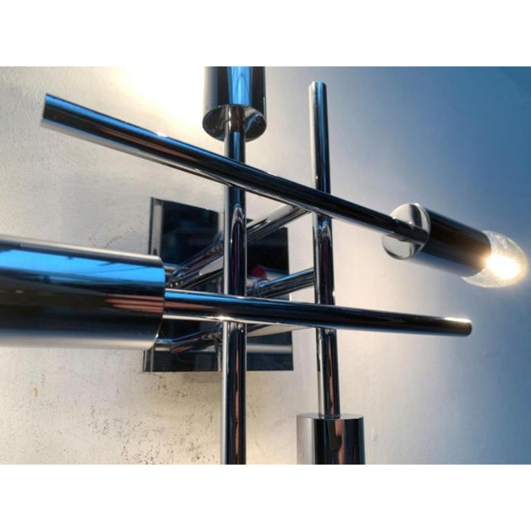 Imposing Space Age wall or ceiling light.

The luminaire consists of four overlapping rods, at the ends of which one sitting is sitting. The elements are arranged at right angles. The reflective chrome surface of the luminaire potents the escaping