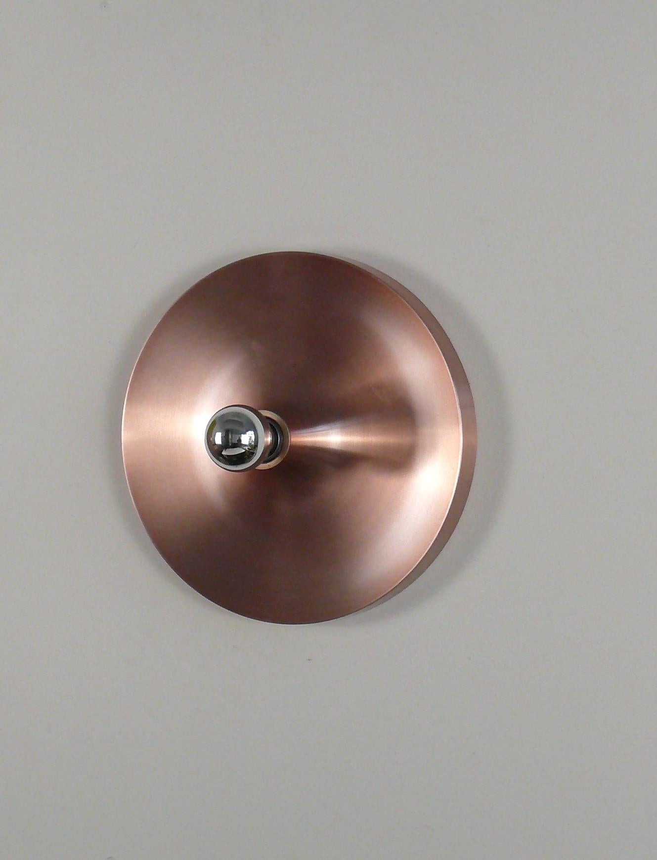 Original discus lamp from the 1960s by Teka (similiar to Honsel), Germany. The lamp is made of brushed aluminum in an old pink coloring, roughly copper-colored, se pictures. It can be attached to both the ceiling and the wall. The lamp has an E 27