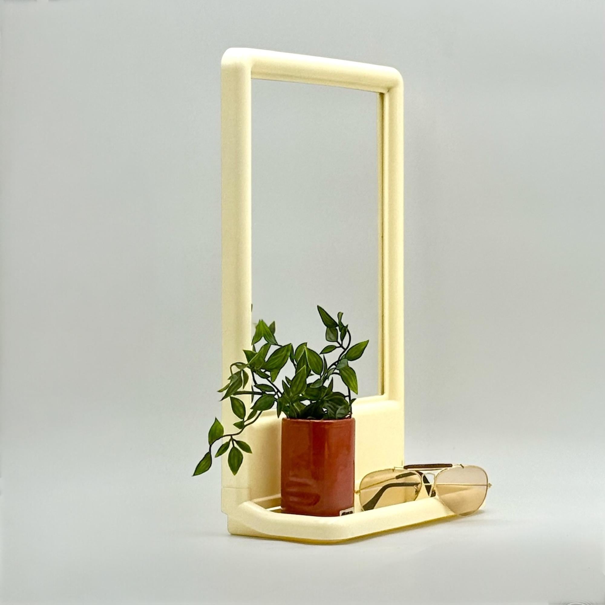 Original vintage 70s mirror, perfect for both table and wall use.

Made in Italy from white plastic with a naturally aged patina, this piece features soft curves and a minimalist design typical of the era. The integrated shelf—removable for added