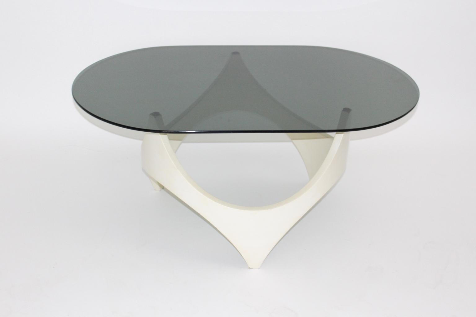 This vintage Space Age coffee table consists of a white lacquered beech wooden base topped with an oval shaped smoked glass top.
The vintage condition is very good.
Approximate measures:
Width 108 cm
Depth 68 cm
Height 45 cm.