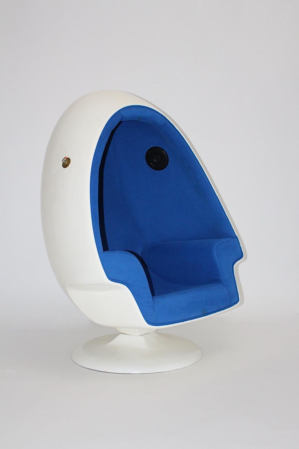 Space Age white fiberglass vintage lounge chair in egg like shape, which features a swiveling function.
The interior is upholstered and covered in cobalt blue structured textile fabric, while the surface was made of white lacquered fiberglass.
Also