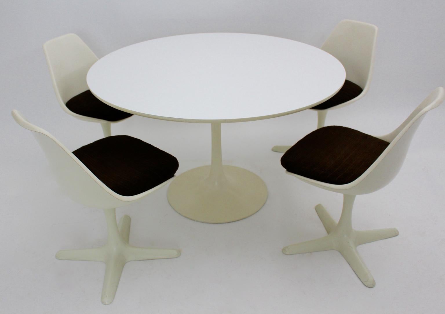Space age vintage white plastic dining room set designed by Maurice Burke 1960s United Kingdom and produced by Arkana Great Britain.
The dining room set consists of 1 white enameled round table with a white formica table top and four swiveling