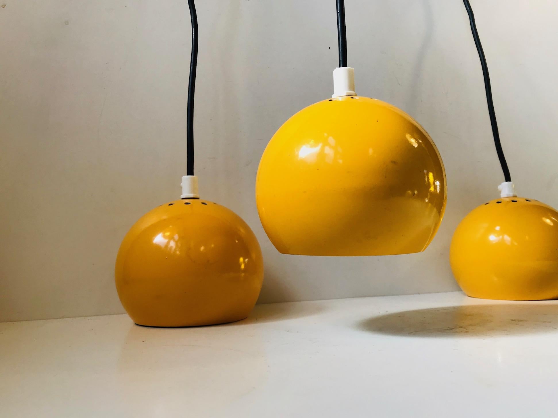 Bundled pendant lamp made from 3 single yellow ball-shaped lampshades. Manufactured and designed by E. S. Horn in Denmark during the 1960s in a style reminiscent of Verner Panton. The 3 lights can be used separately and 3 black canopies are included