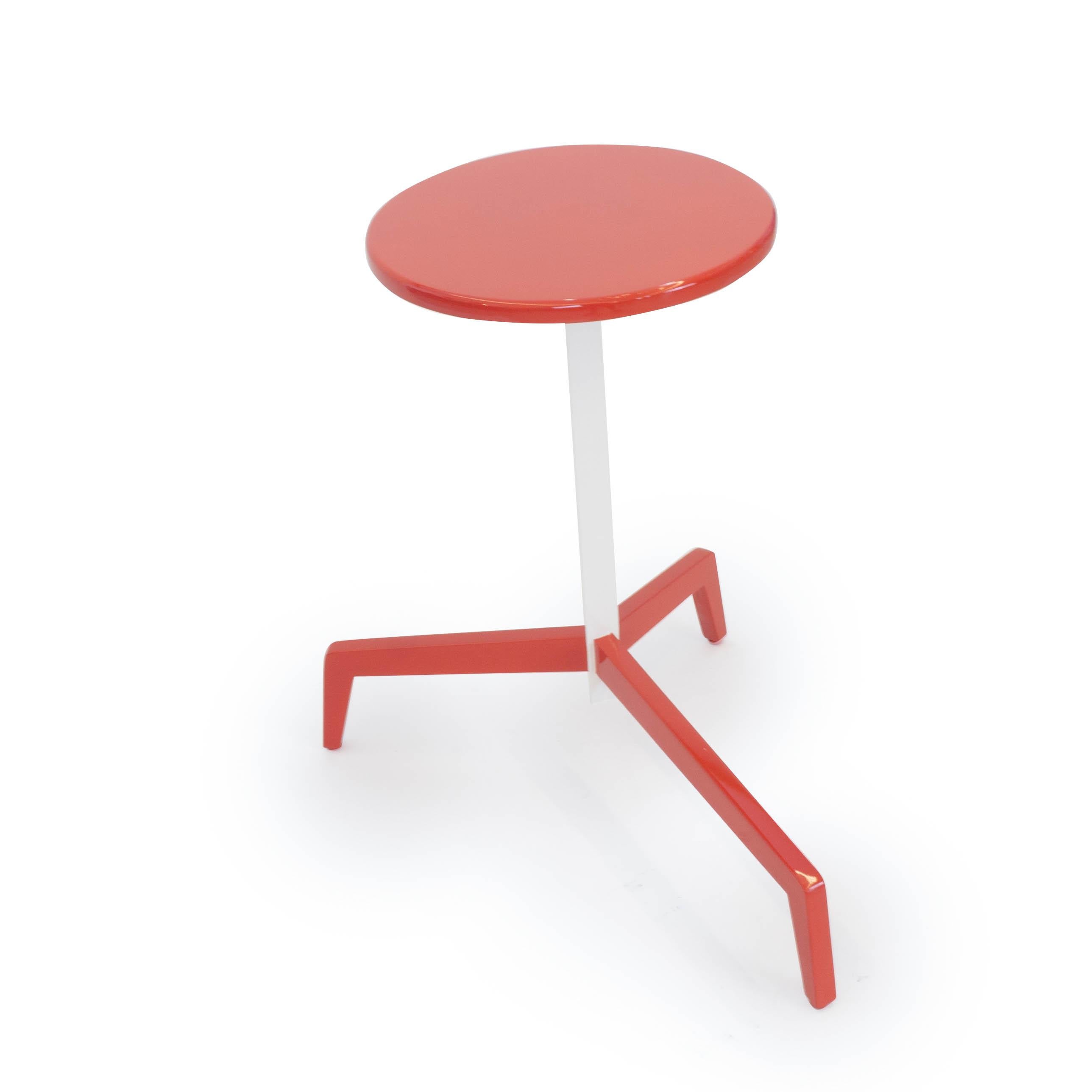 This red and white lacquered side table is conveniently designed to fit in any room. The long protruding leg slides under tables and benches to maximize your space. This table can be sold as is or custom made in any color of the customers' choosing.