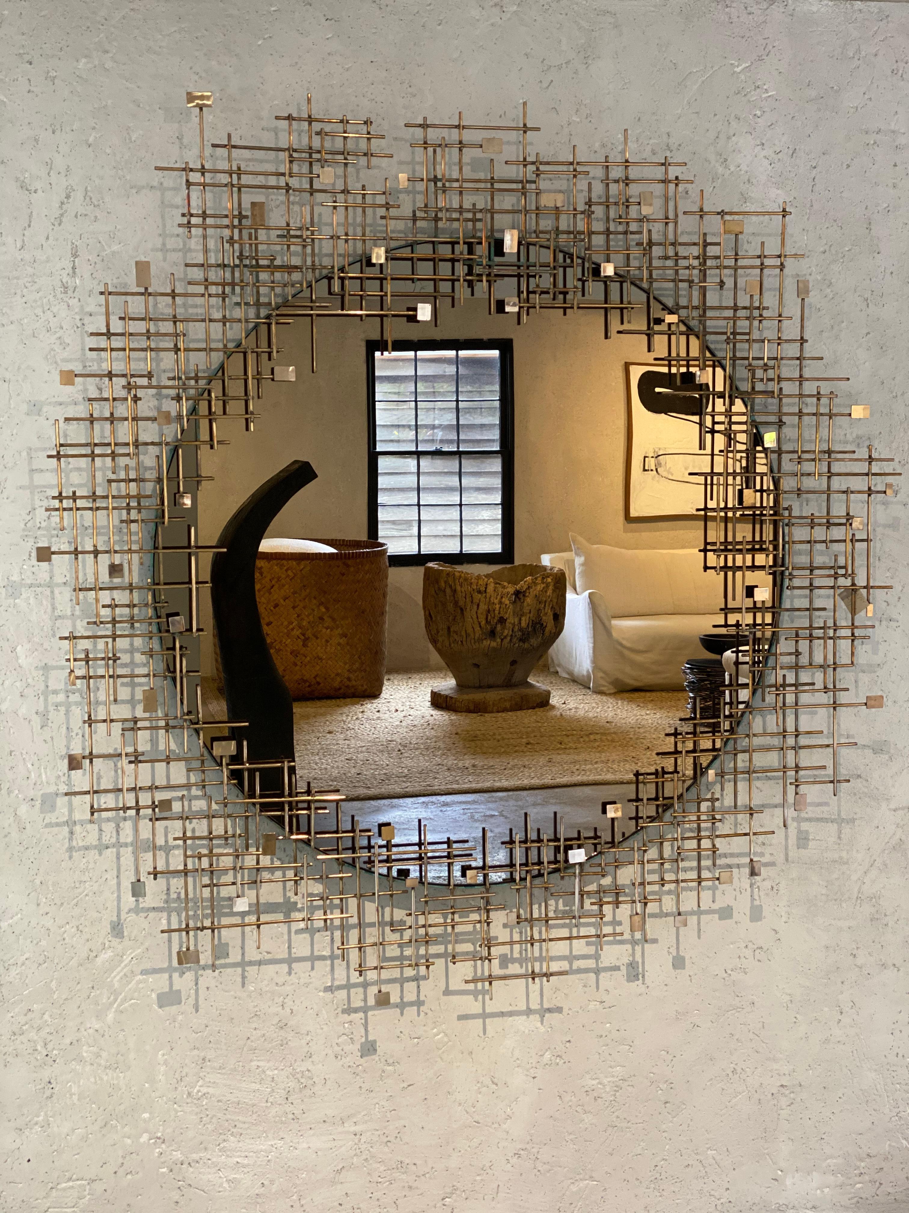 A beautiful bronze tinted mirror with a lattice work of bronze framing. Subtle patina runs throughout the piece.