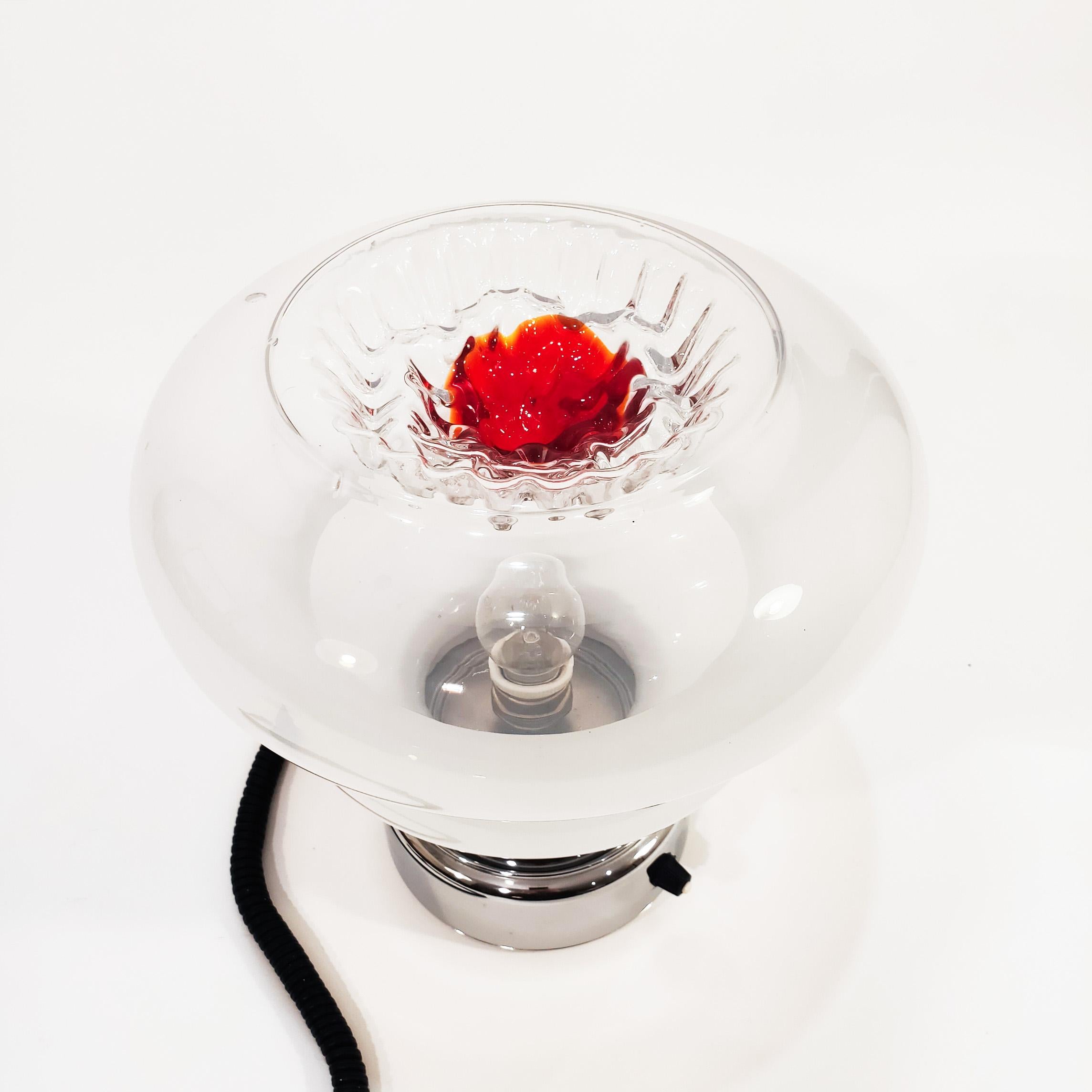 Italian Spaceage table lamp in the style of Toni Zuccheri's artistic creations. Murano glass tulip with organic shapes combining the smoky tone with transparent and red. Chrome metal base structure with built-in switch. All original. Very much in